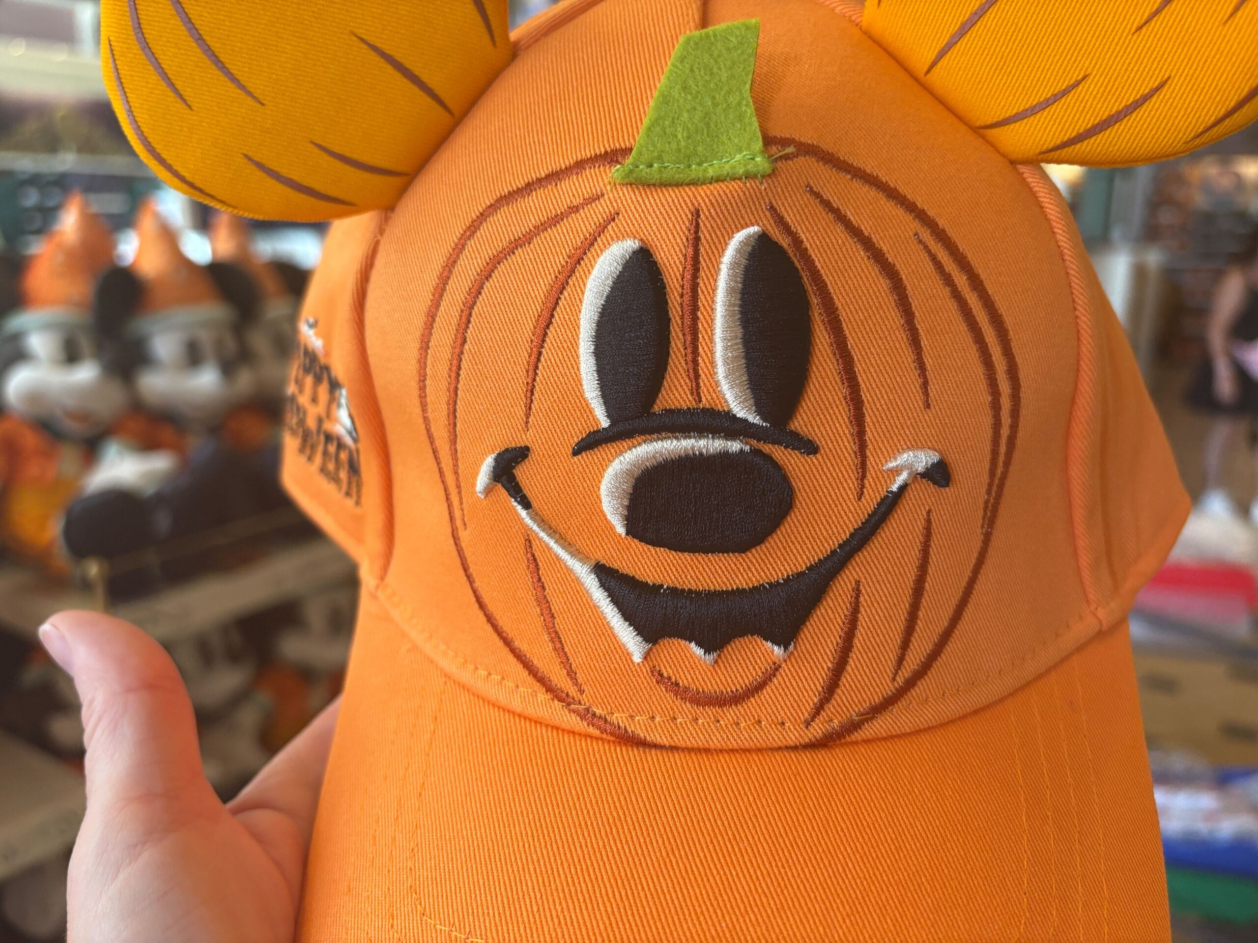 Orange Halloween hat with Mickey Mouse ears, part of Walt Disney World Halloween Merchandise, held in someone's hand.