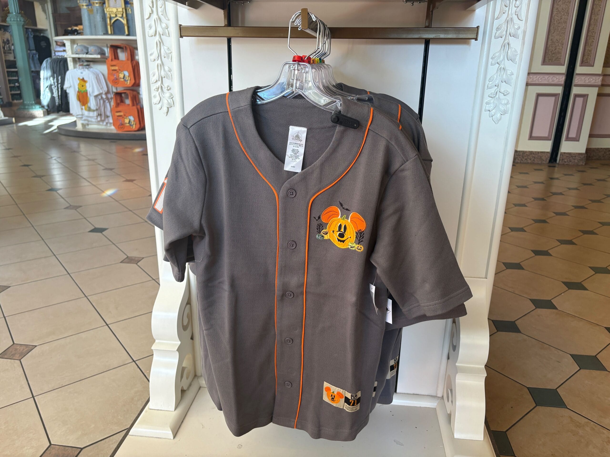 Gray baseball jersey with orange trim, part of Walt Disney World Halloween merchandise, features a smiling Mickey pumpkin patch.