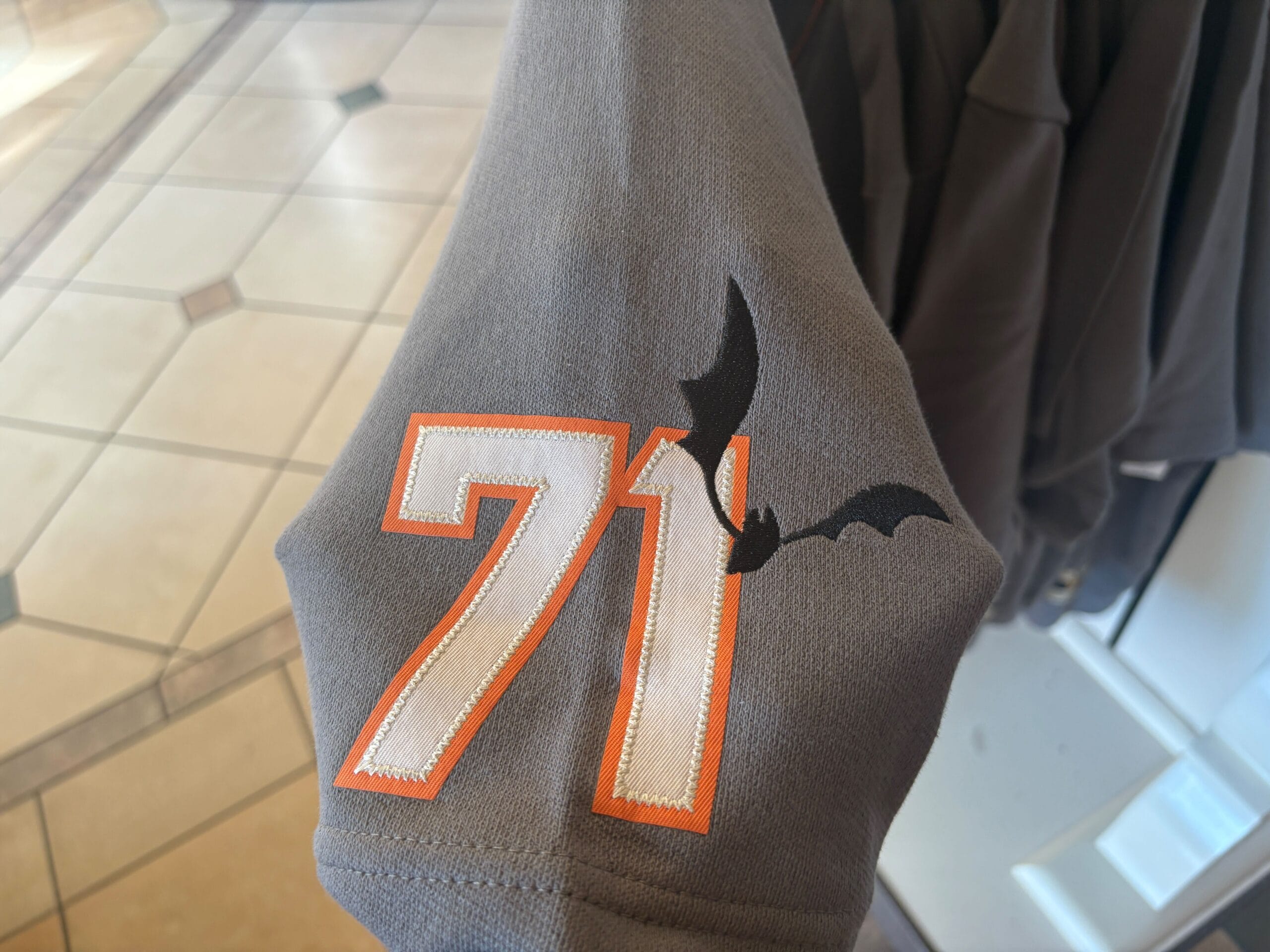 Gray fabric with 71 outlined in orange and white, plus a black bat—perfect for Halloween merchandise lovers.