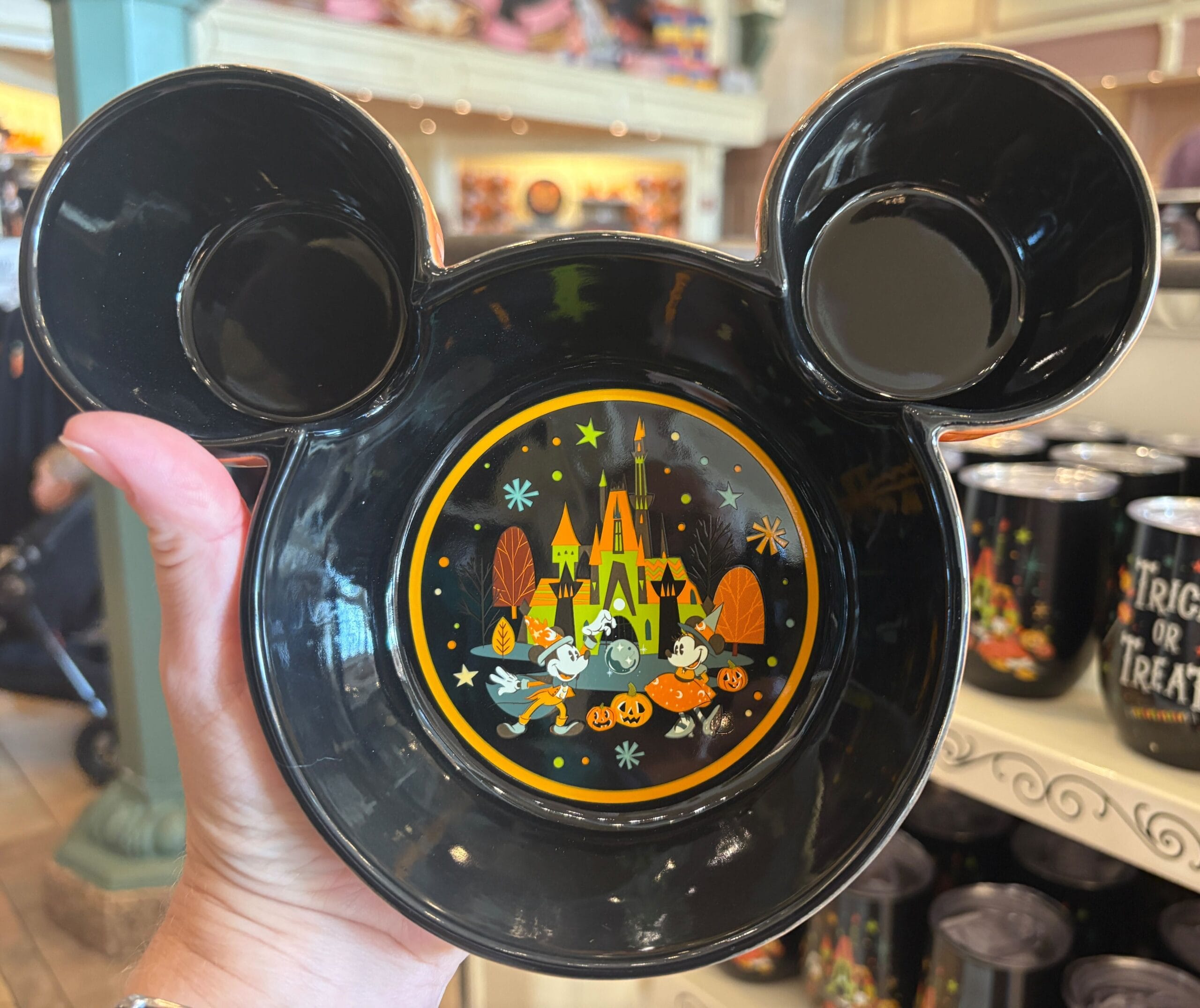 Black Mickey Mouse-shaped bowl featuring Walt Disney World Halloween merchandise, displayed in-store with charming characters.