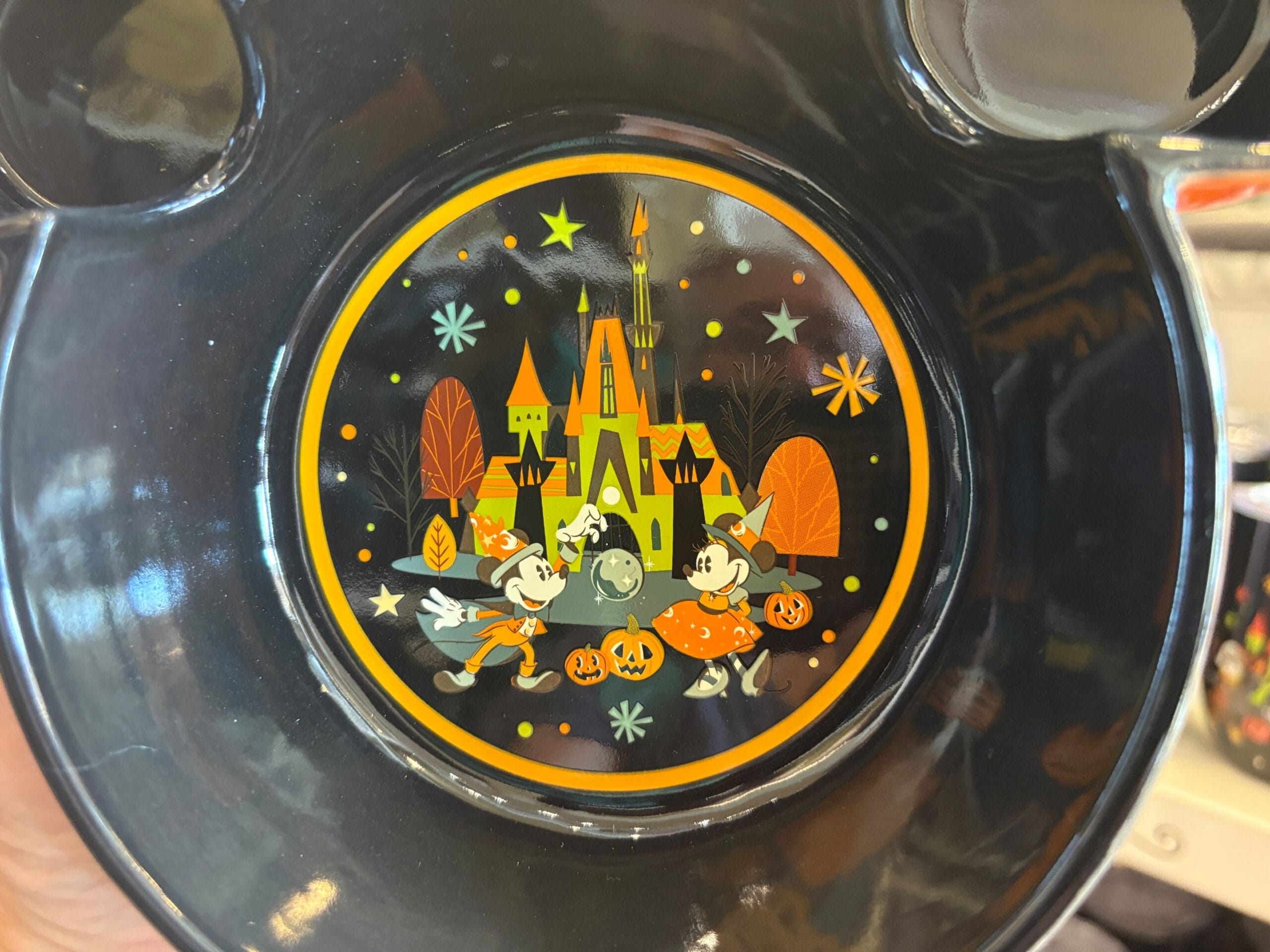 Mickey and Minnie in Halloween costumes with pumpkins at Walt Disney World, surrounded by stars and autumn trees.