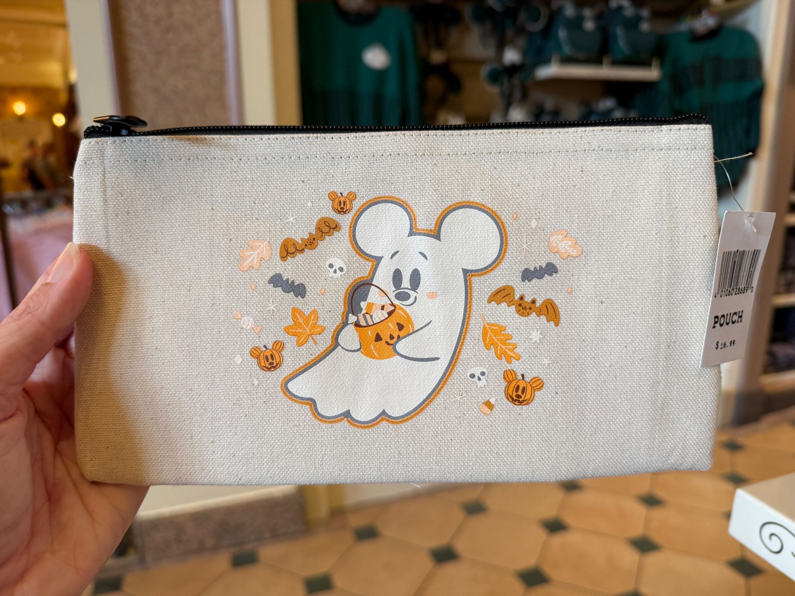 A pouch featuring a ghost with mouse ears holding a pumpkin, perfect for fans of Disney Halloween merch.