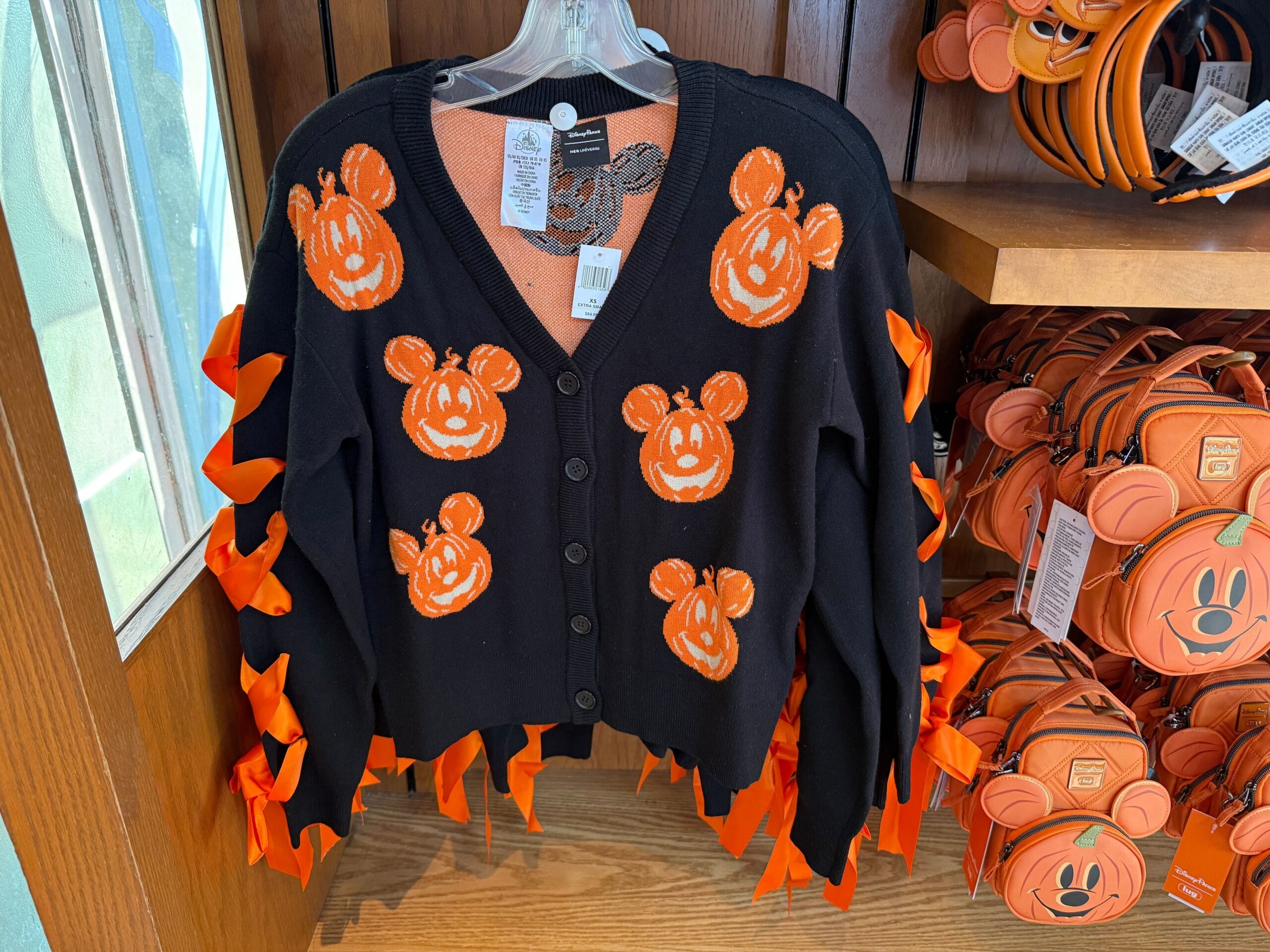 Black cardigan with orange Mickey Mouse pumpkin faces and ribbon, perfect for Halloween at Disney World.