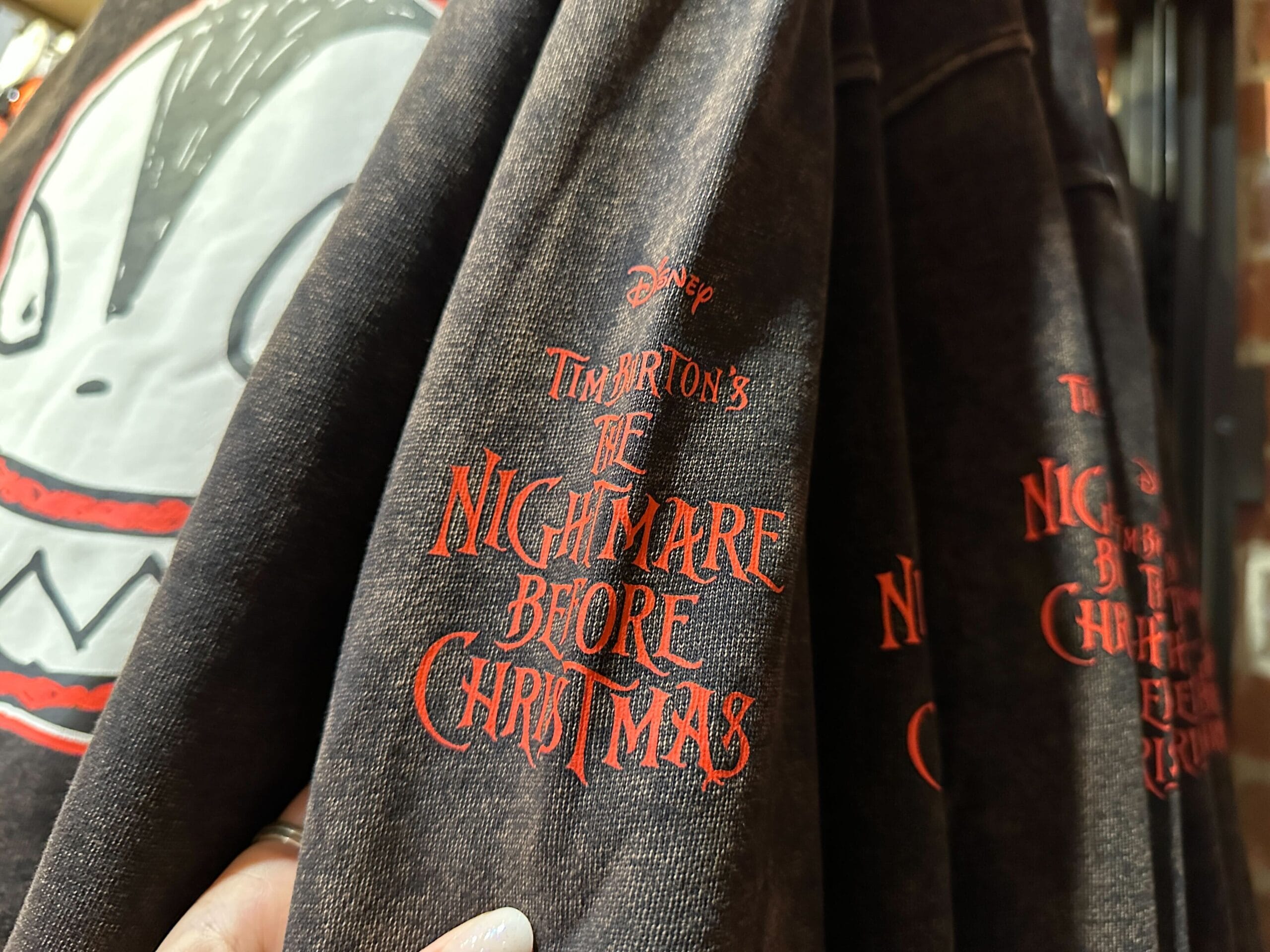 Close-up of Disney Halloween merch featuring "The Nightmare Before Christmas" logo and a white face graphic.