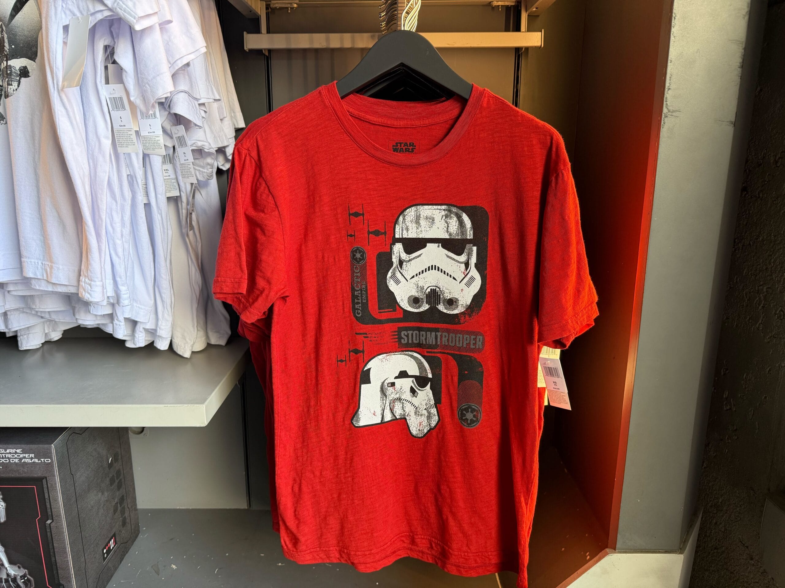 Red T-shirt with Star Wars stormtrooper helmet illustrations, perfect for fans shopping Star Wars shirts at Disneyland.
