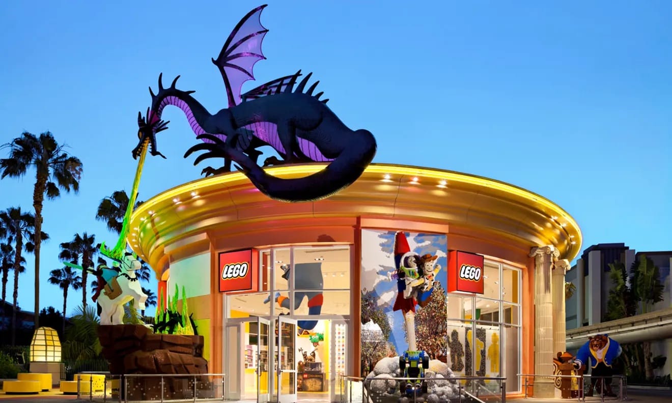 LEGO Store at Downtown Disney with a large dragon sculpture, colorful displays, and palm trees by the entrance.