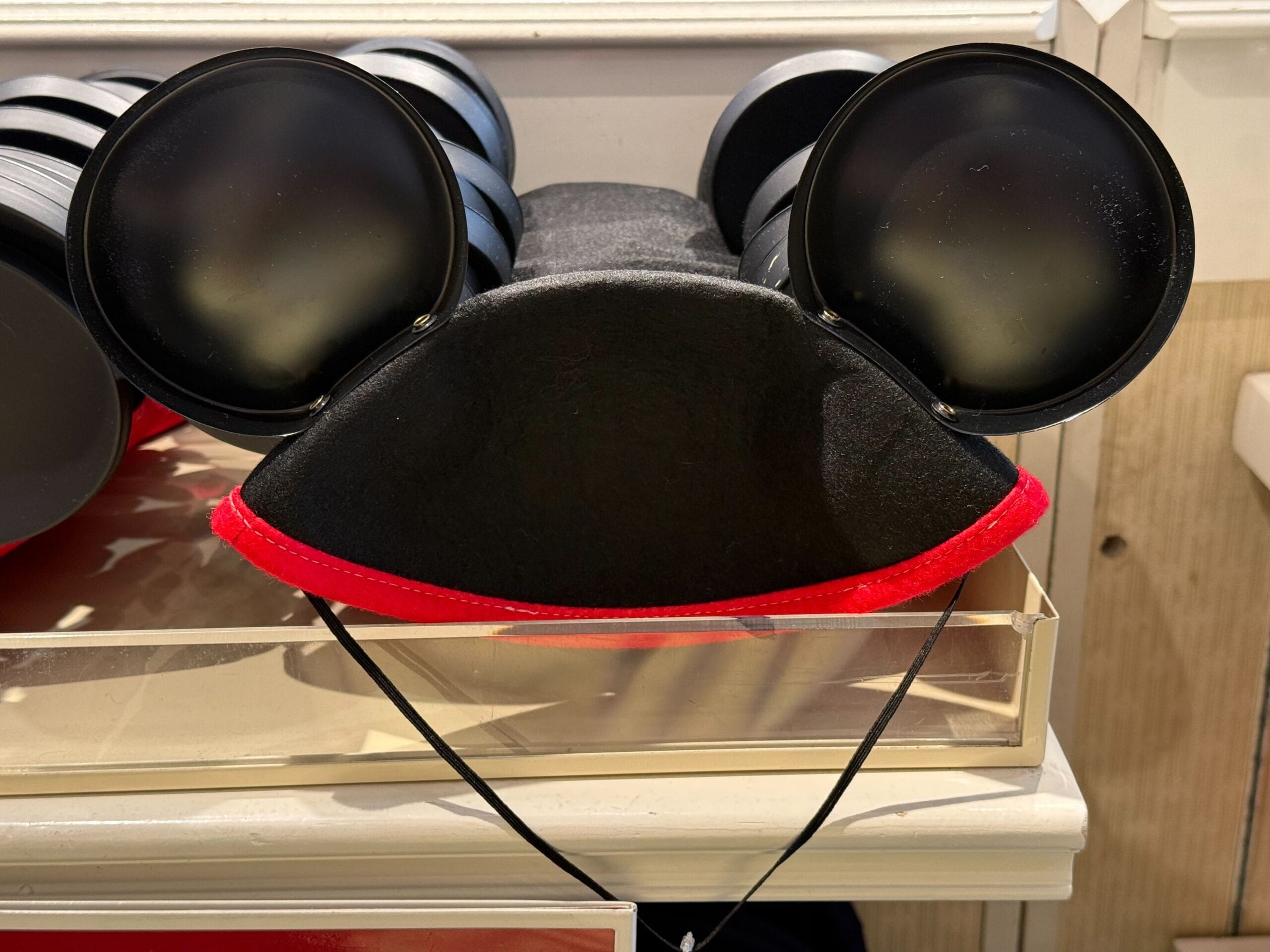 Black Mickey Mouse ears hat with red trim, a classic piece of Mickey Mouse Club merchandise for Disneyland's 70th anniversary.