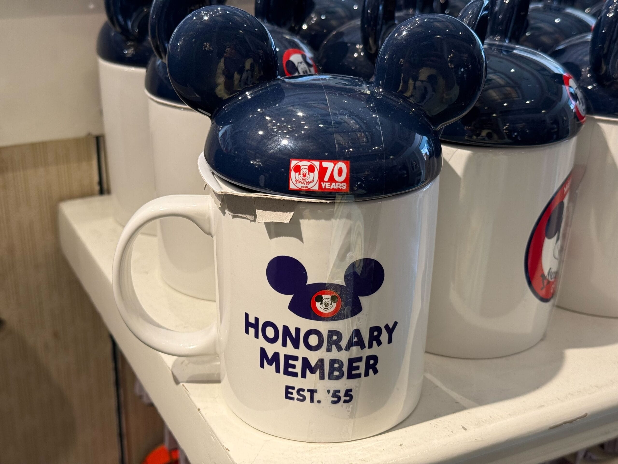 White mug with Mickey Mouse ears lid, "Honorary Member EST. '55"—perfect Mickey Mouse Club merchandise for Disneyland’s 70th anniversary.