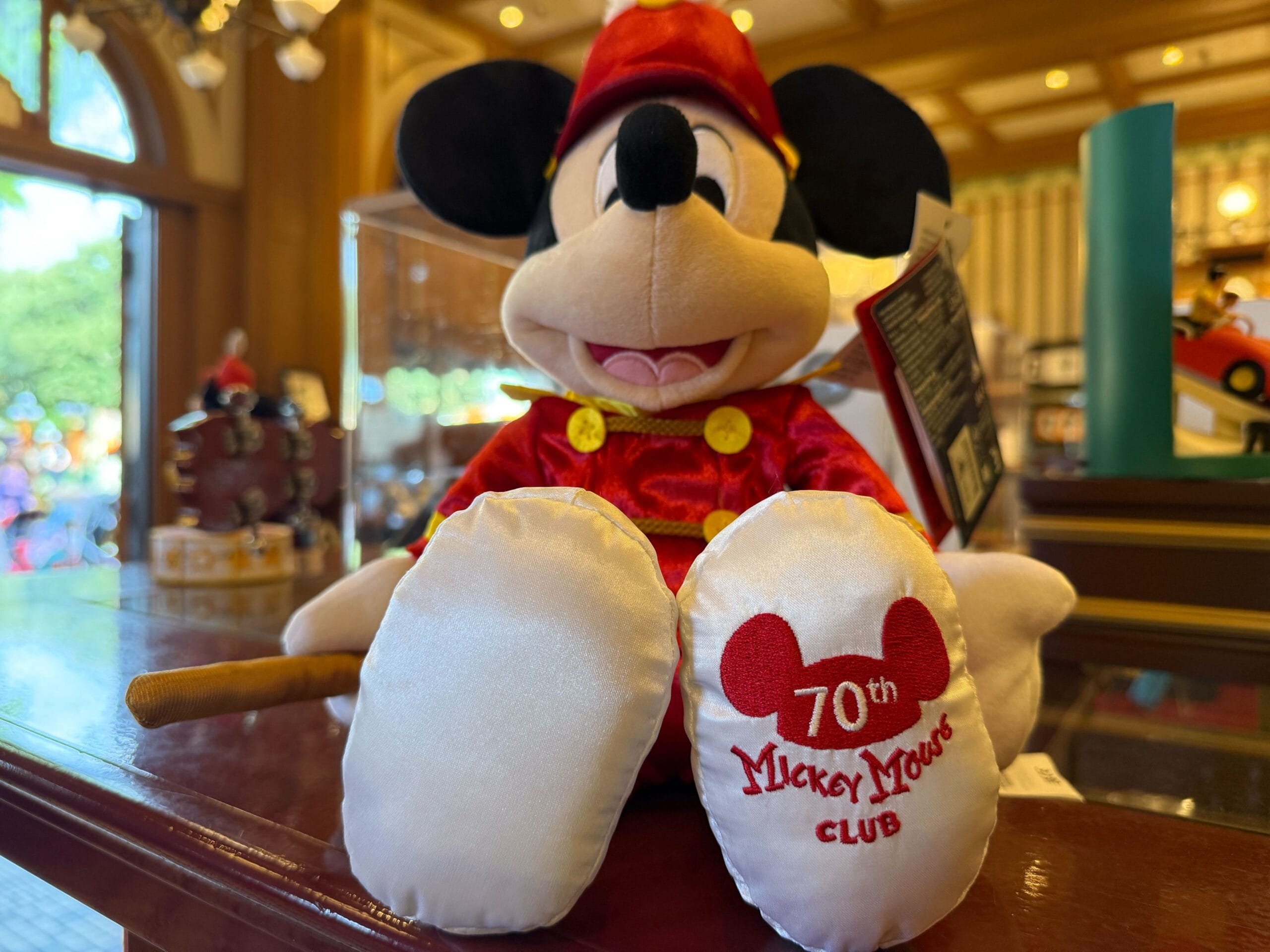 A plush Mickey Mouse toy dressed in red, part of special 70th anniversary Mickey Mouse Club merchandise.