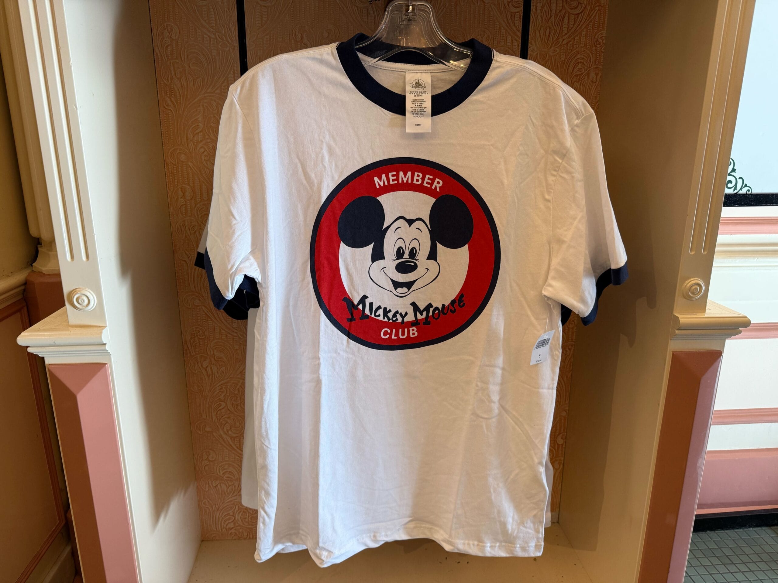White t-shirt with blue trim, featuring Mickey Mouse and "Member Mickey Mouse Club" logo—classic Disneyland merchandise.