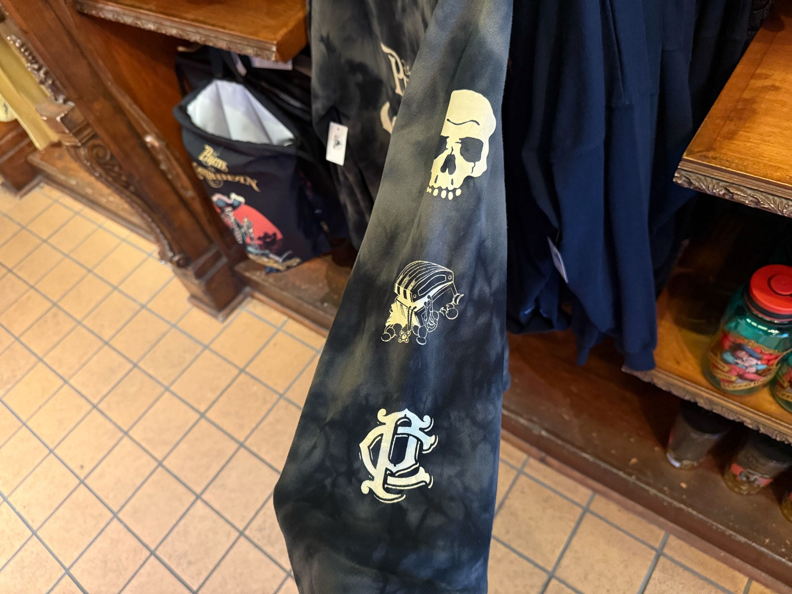 A sleeve inspired by Pirates of the Caribbean, with skull, treasure chest, and anchor on black and gray tie-dye fabric.