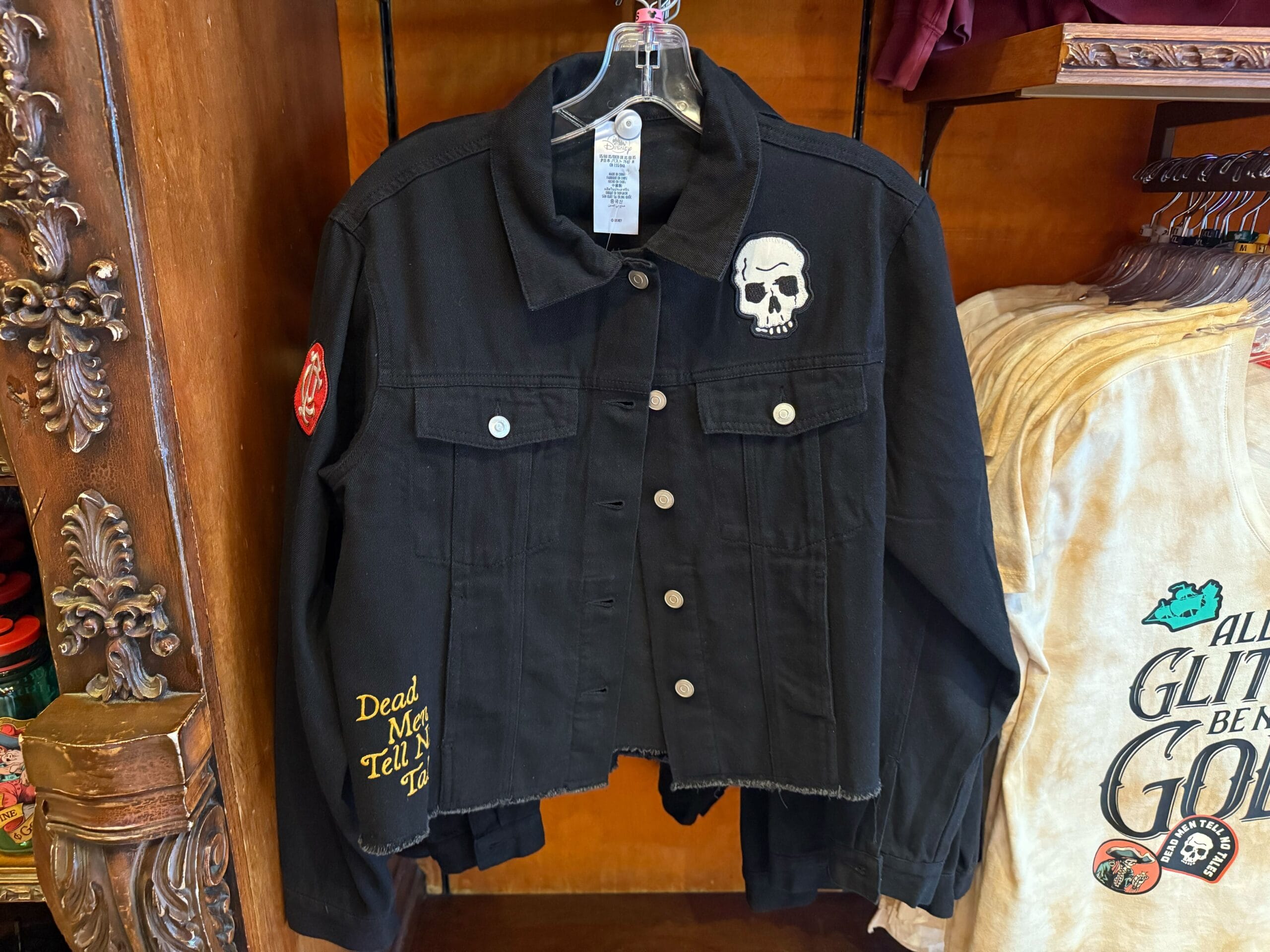 Black denim jacket inspired by Pirates of the Caribbean, featuring skull and red patches—perfect Disneyland apparel.