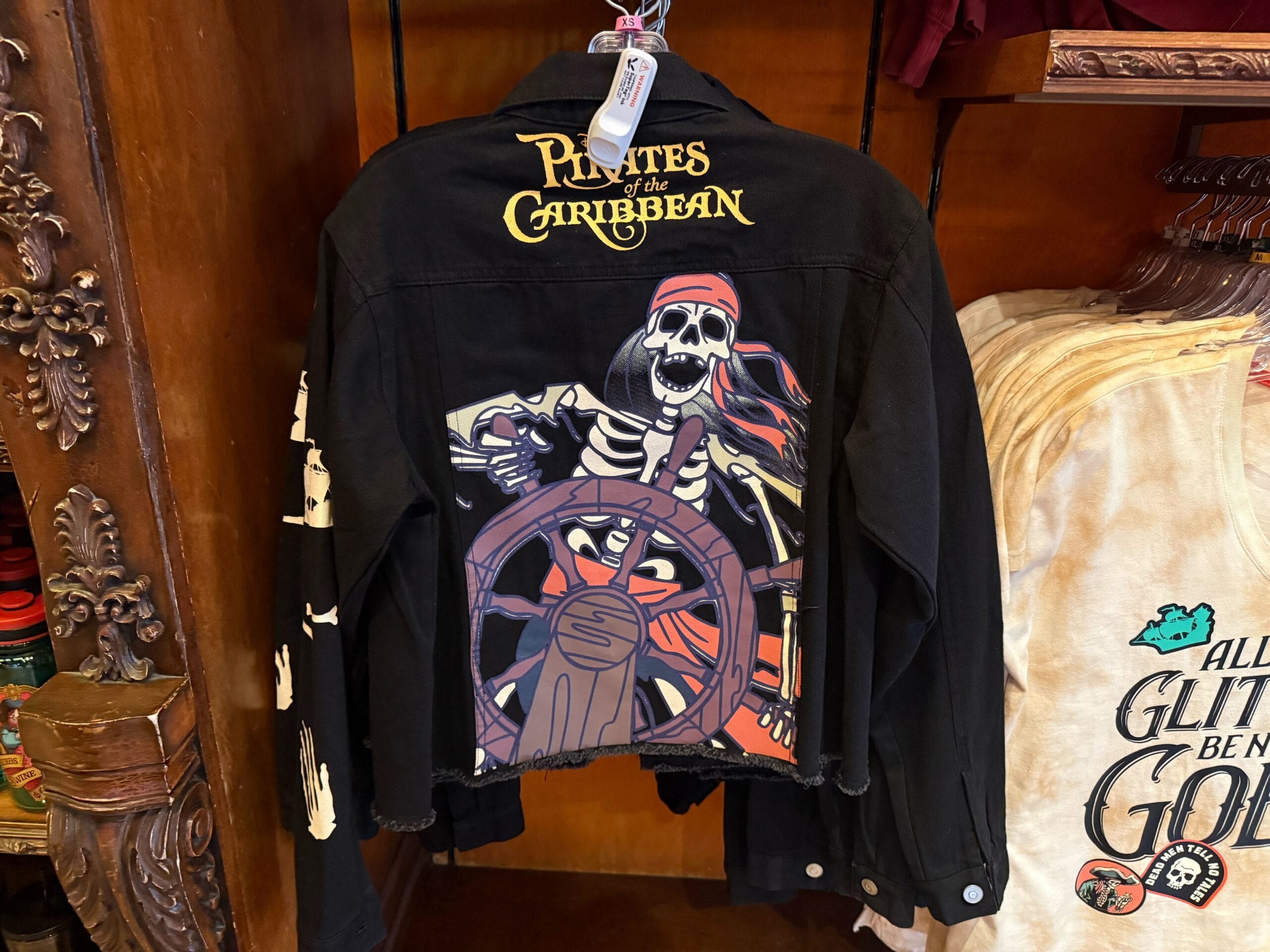 Black Pirates of the Caribbean jacket with a skeleton pirate design on the back, perfect Disneyland apparel.