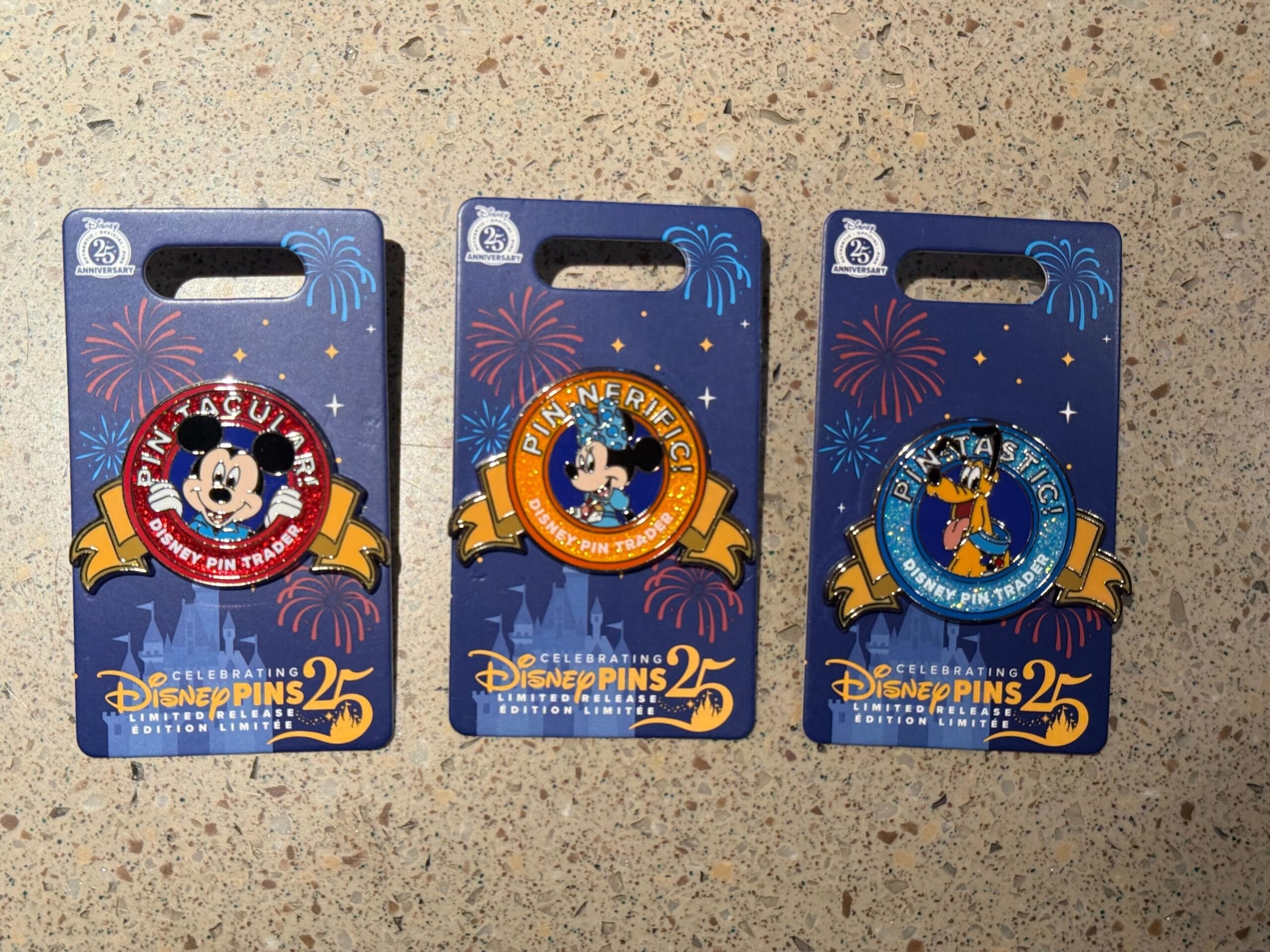 Three Disneyland pins featuring Mickey and Friends, celebrating Pin Trading 25th Anniversary with fireworks packaging.