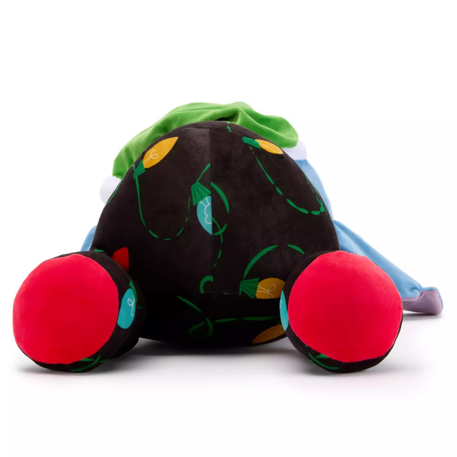Plush toy lying face down, black body with lights, red feet, green hat—part of 2025 Disney Christmas merchandise.