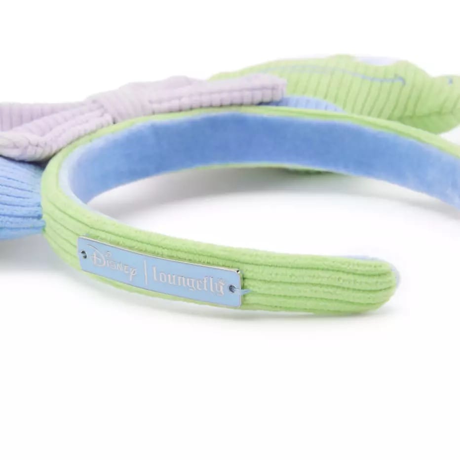 A pastel Loungefly Alien Ear Headband in green and blue with a metallic Disney logo plaque on the side.