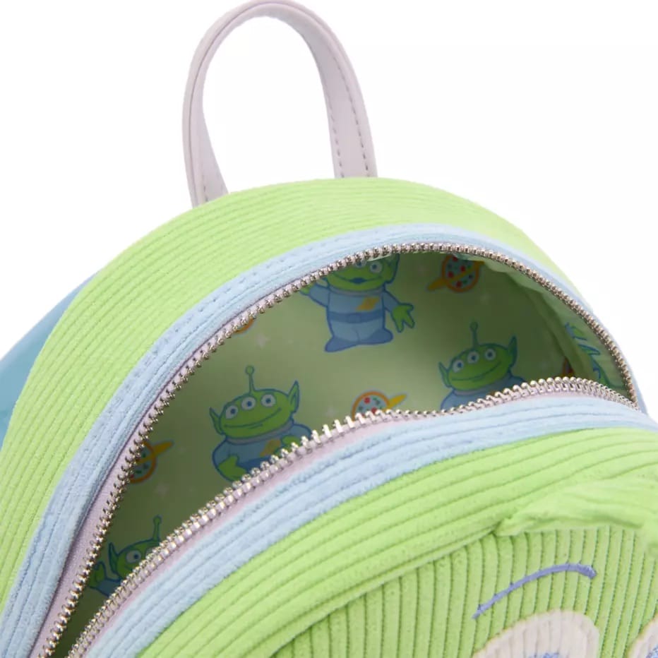 Close-up of a green and blue Loungefly Backpack with an alien pattern lining inside the open zipper pocket.