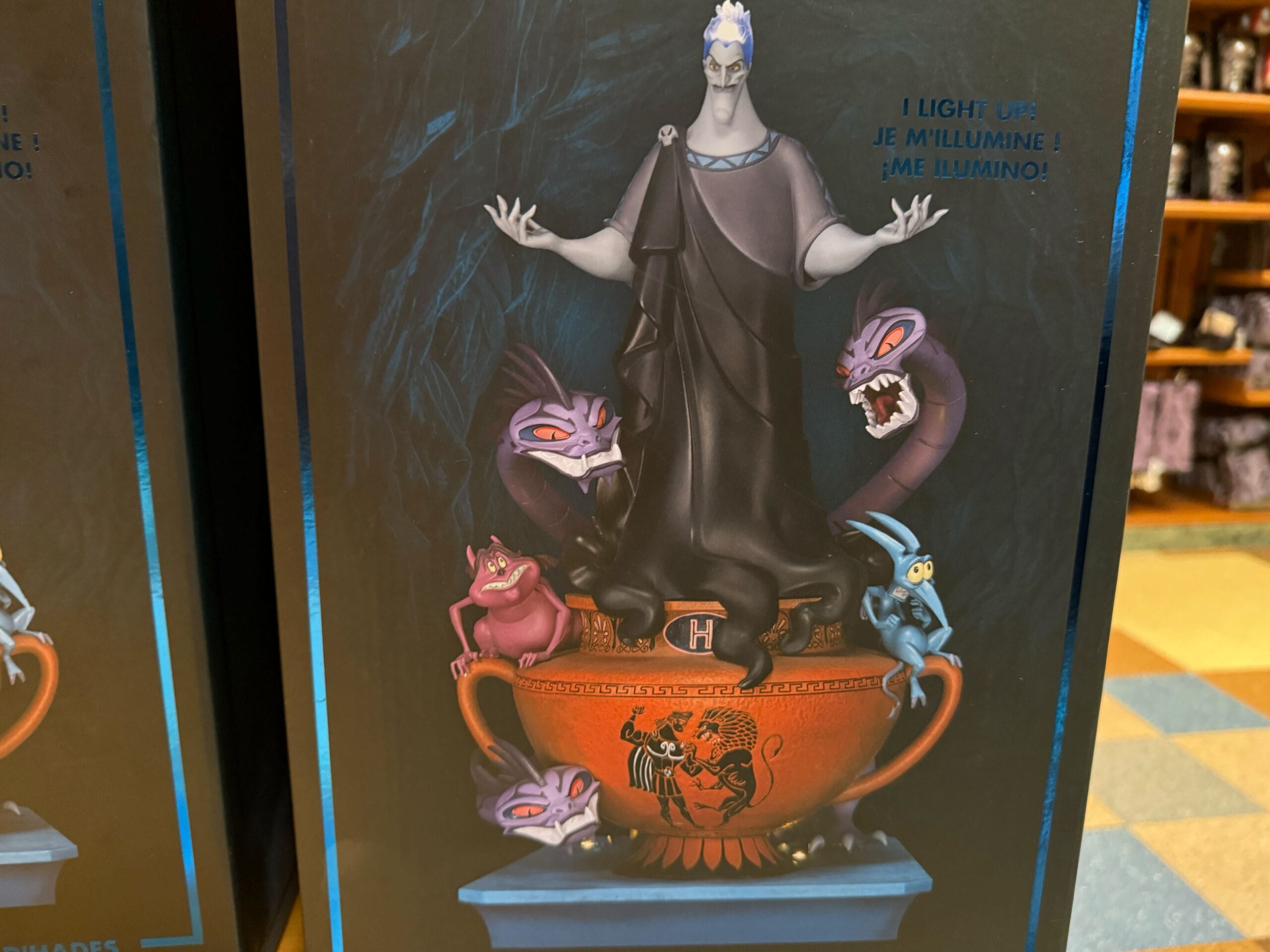 A Hades Figure stands on a fiery red bowl, surrounded by three mythological creatures and two Disney Villains imps.