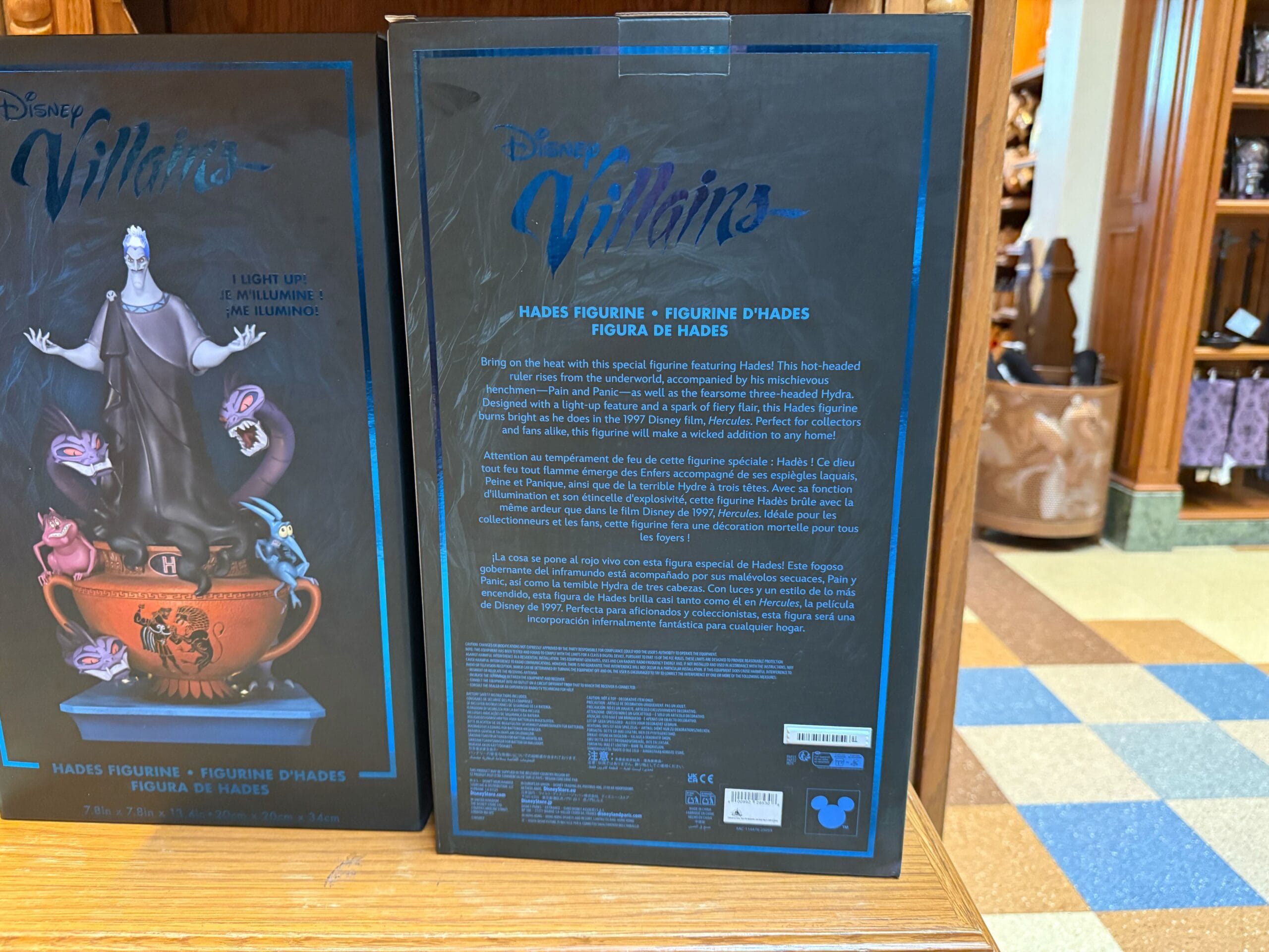 Disney Villains Hades Figure box displayed on a wooden shelf at California Adventure, product details clearly visible.