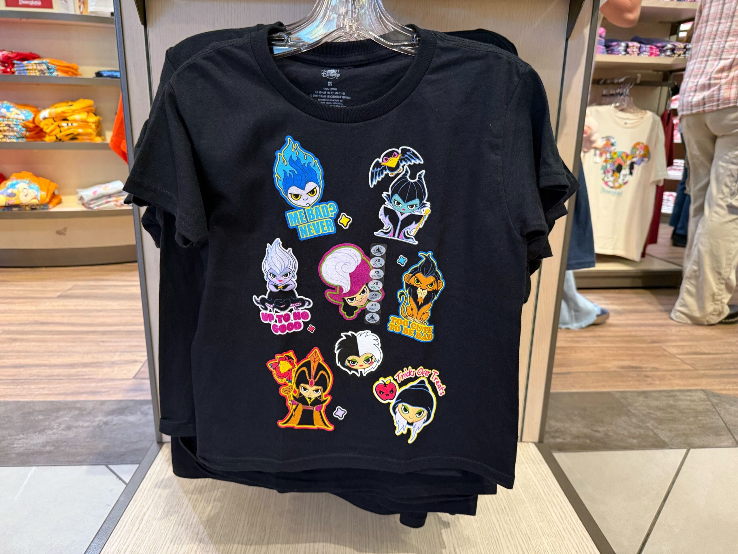 Black T-shirt with colorful cartoon Disney villains and phrases—perfect Disneyland or Halloween merchandise on display.