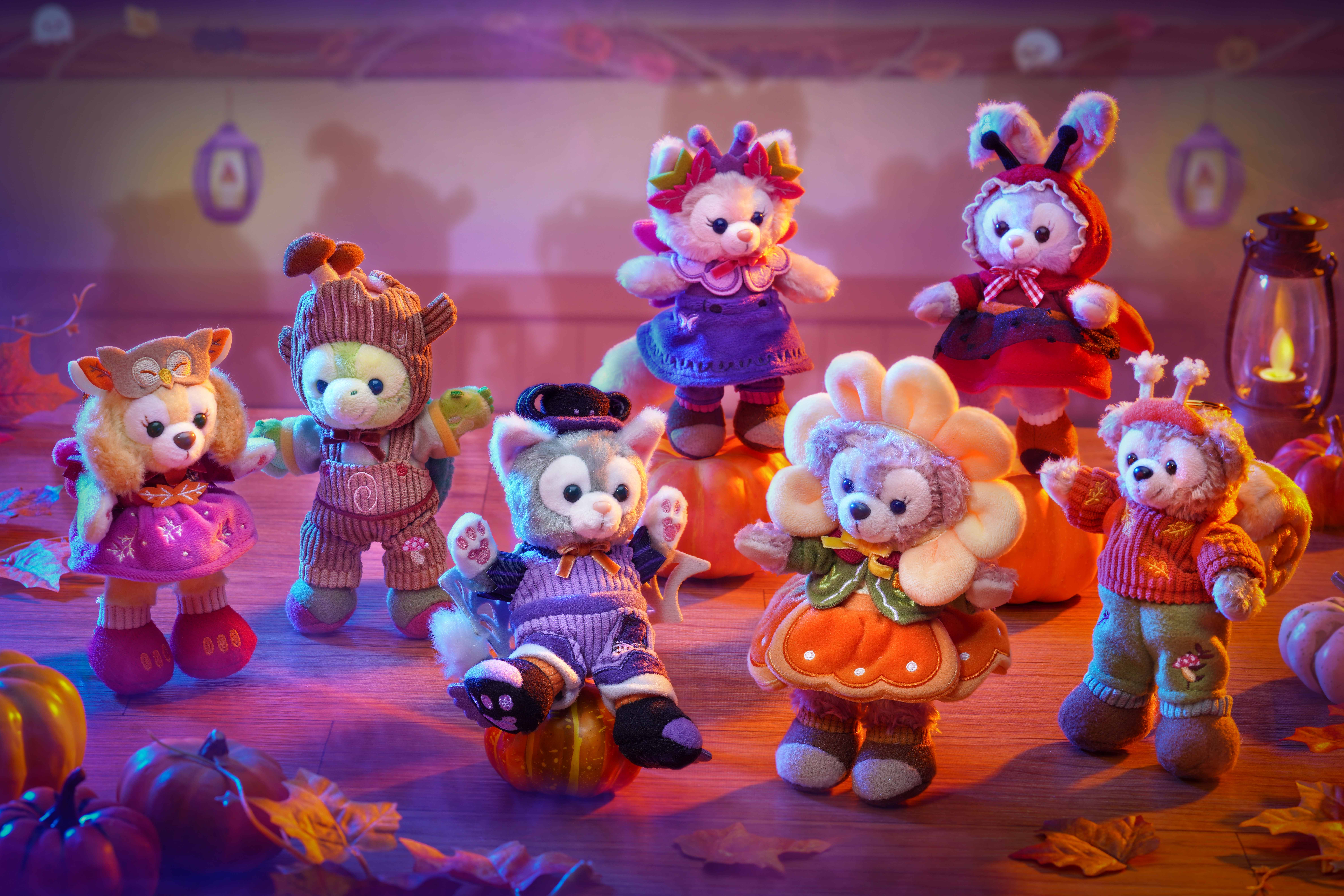 Plush animals dressed in Disney Villains Halloween costumes, posed among pumpkins and leaves indoors.