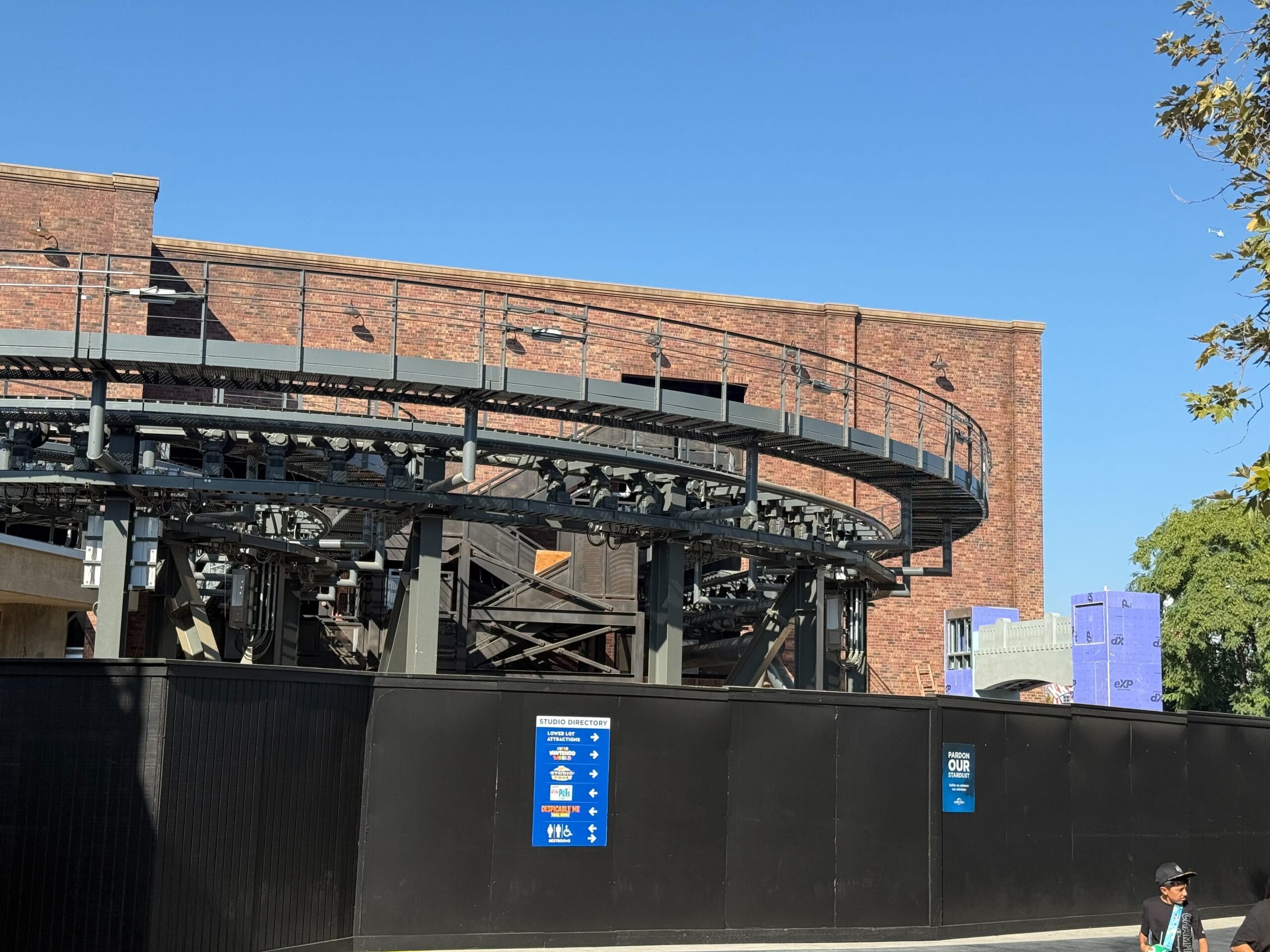 Roller coaster tracks curve in and out of the brick show building for Fast & Furious: Hollywood Drift at Universal Studios Hollywood.