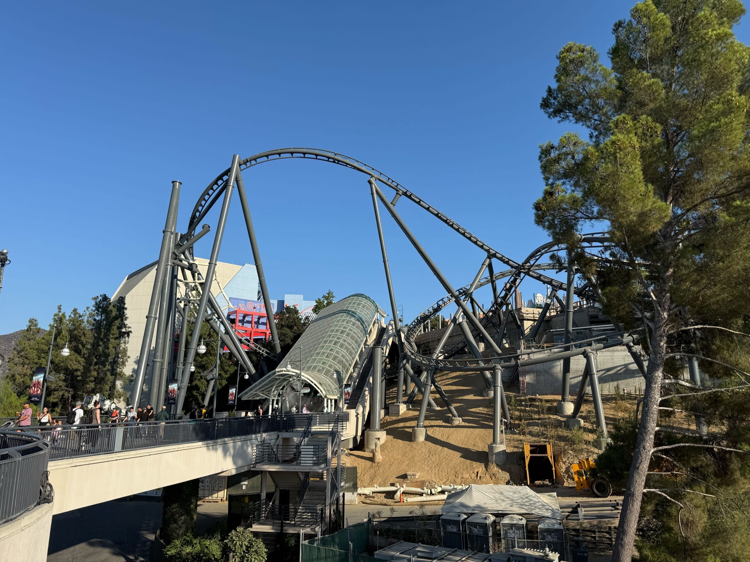 The Fast & Furious: Hollywood Drift roller coaster track above and on the hill next to the glass escalator canopy on the Upper Lot at Universal Studios Hollywood.