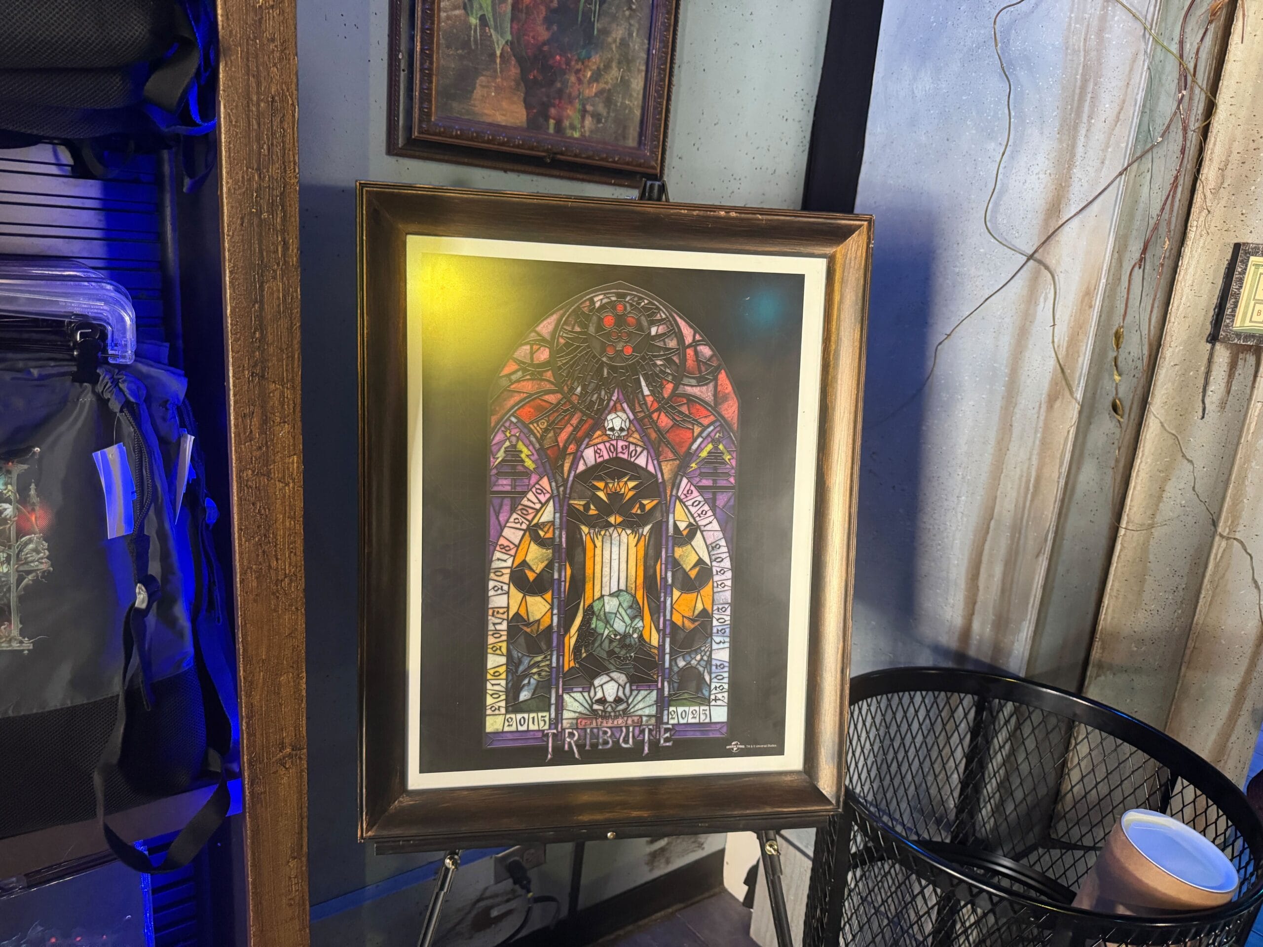 Framed poster of a stained glass window with "TRIBUTE," inspired by the Anniversary Tribute Store, displayed on an easel.