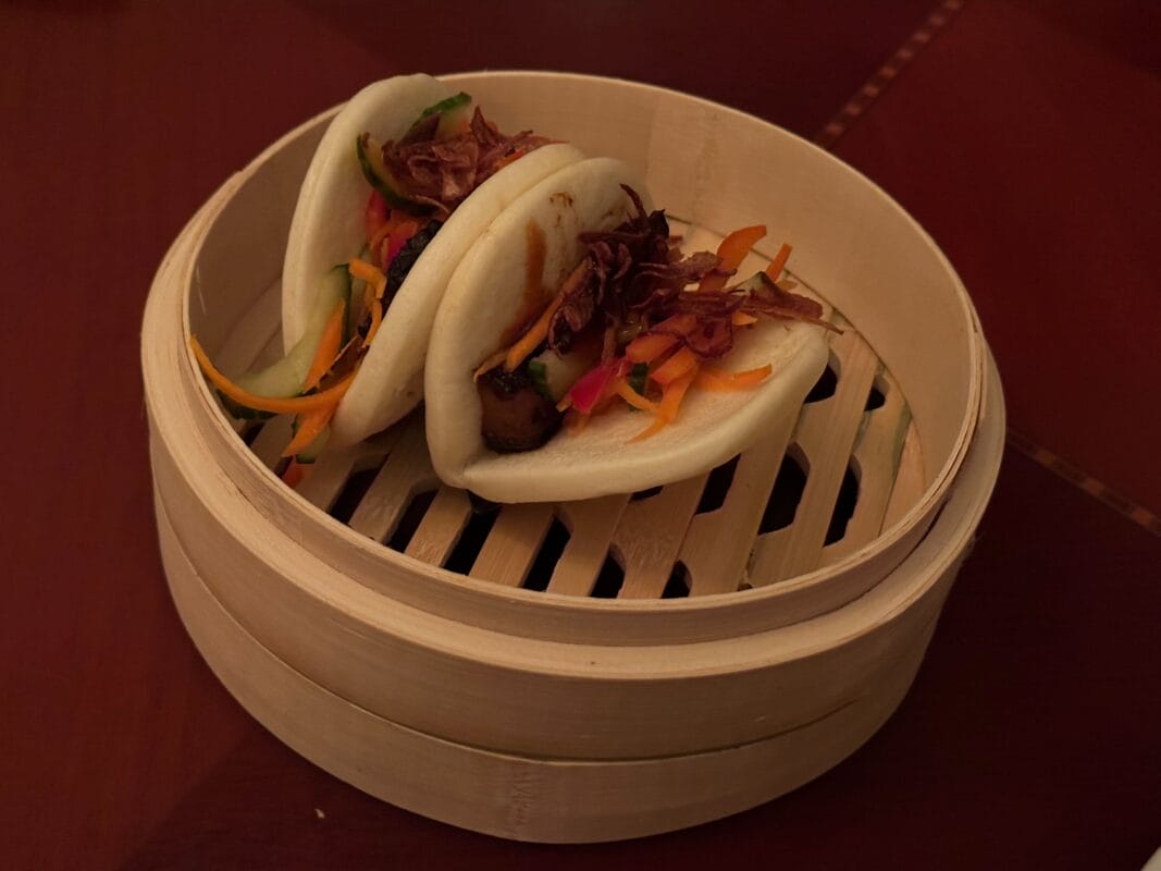 Two steamed bao buns with pork belly and veggies from the Jazzy Holidays menu at The Hollywood Brown Derby.