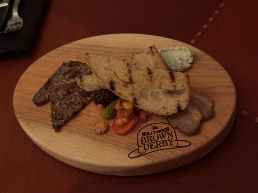 The Hollywood Brown Derby wooden platter with grilled bread, pâté, meats, and cheese.