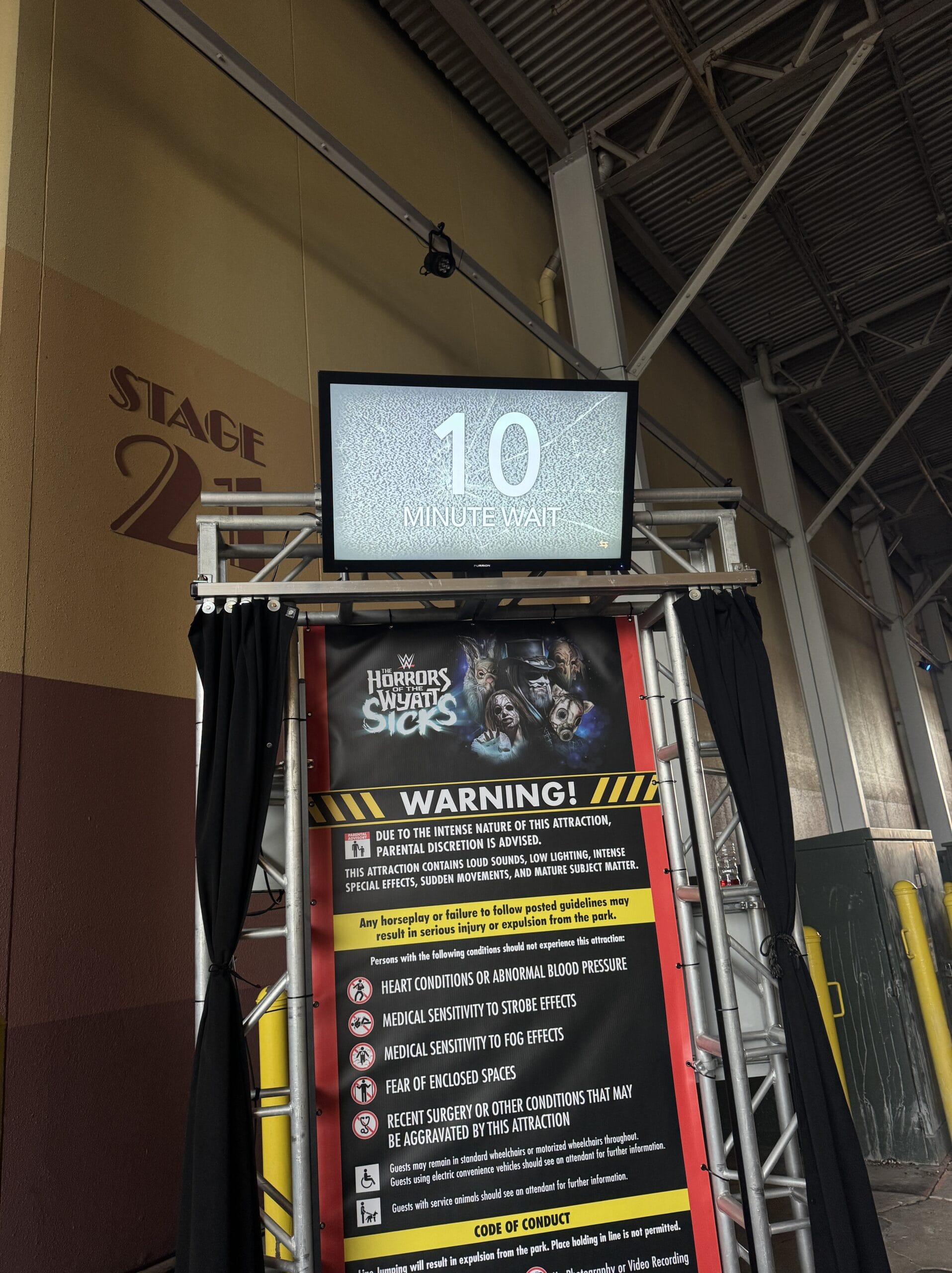 A sign displays "10 minute wait" above a Rush of Fear warning for the haunted attraction at Halloween Horror Night 2025.