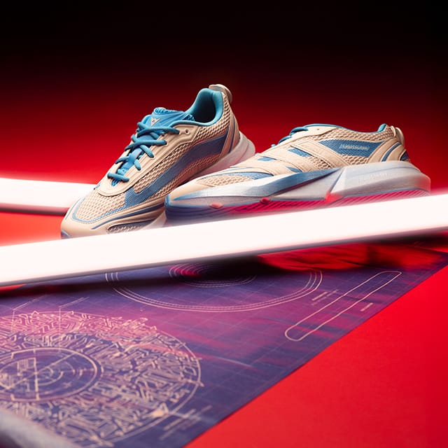 A pair of white and blue Adidas TRON: Ares Lightblaze sneakers.
