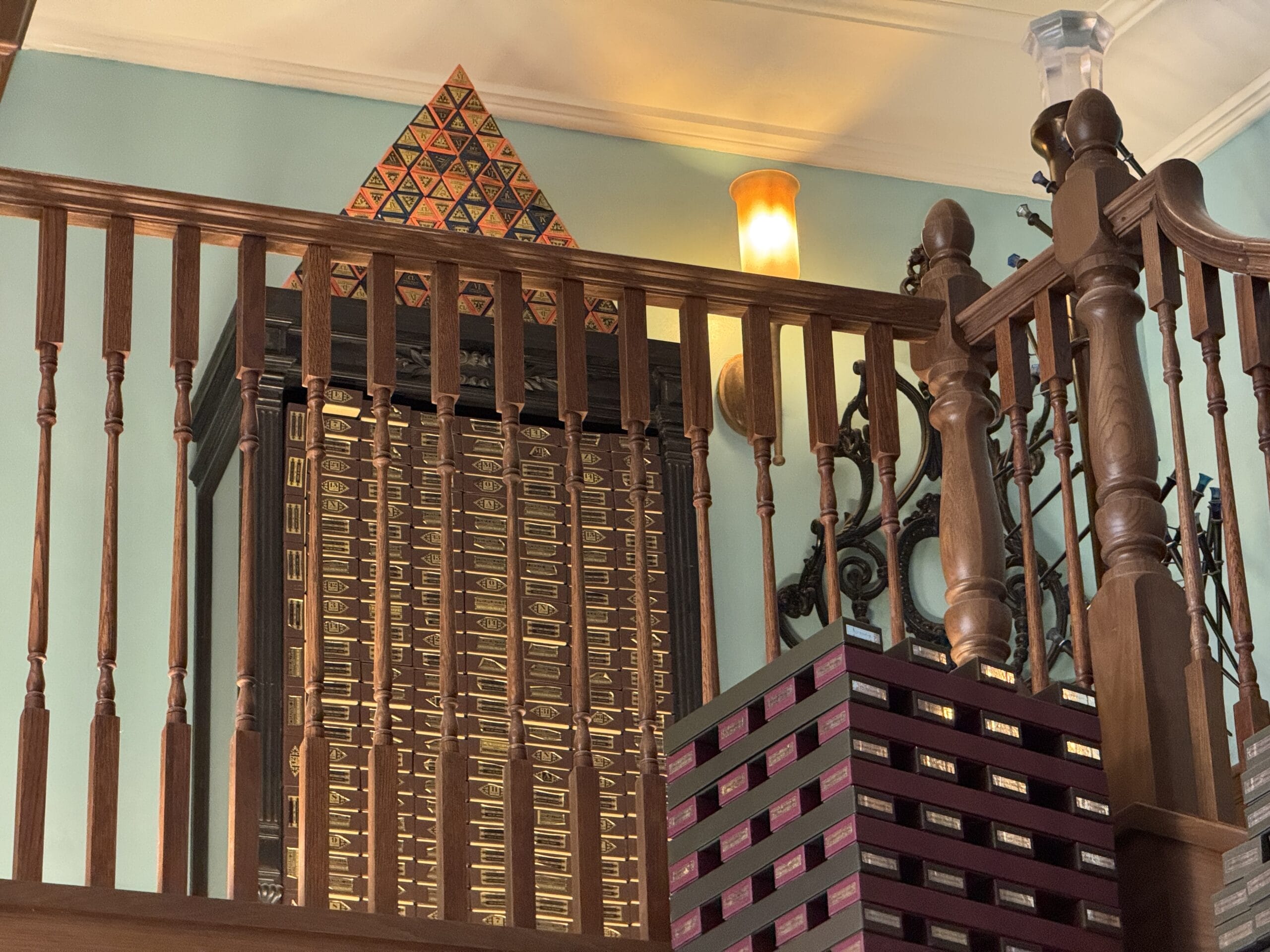 Wooden railings in front of stacked boxes and a Cosme Acajor pyramid brighten a room with vintage decor.