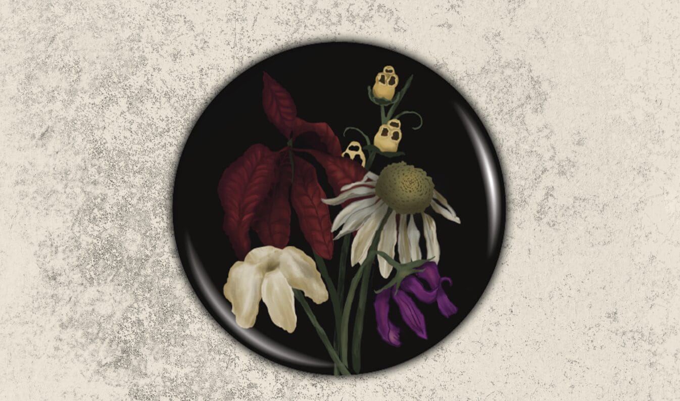 A round black plate, like a button, features illustrated flowers—white daisy, red leaves, and yellow blossoms—on a textured background.