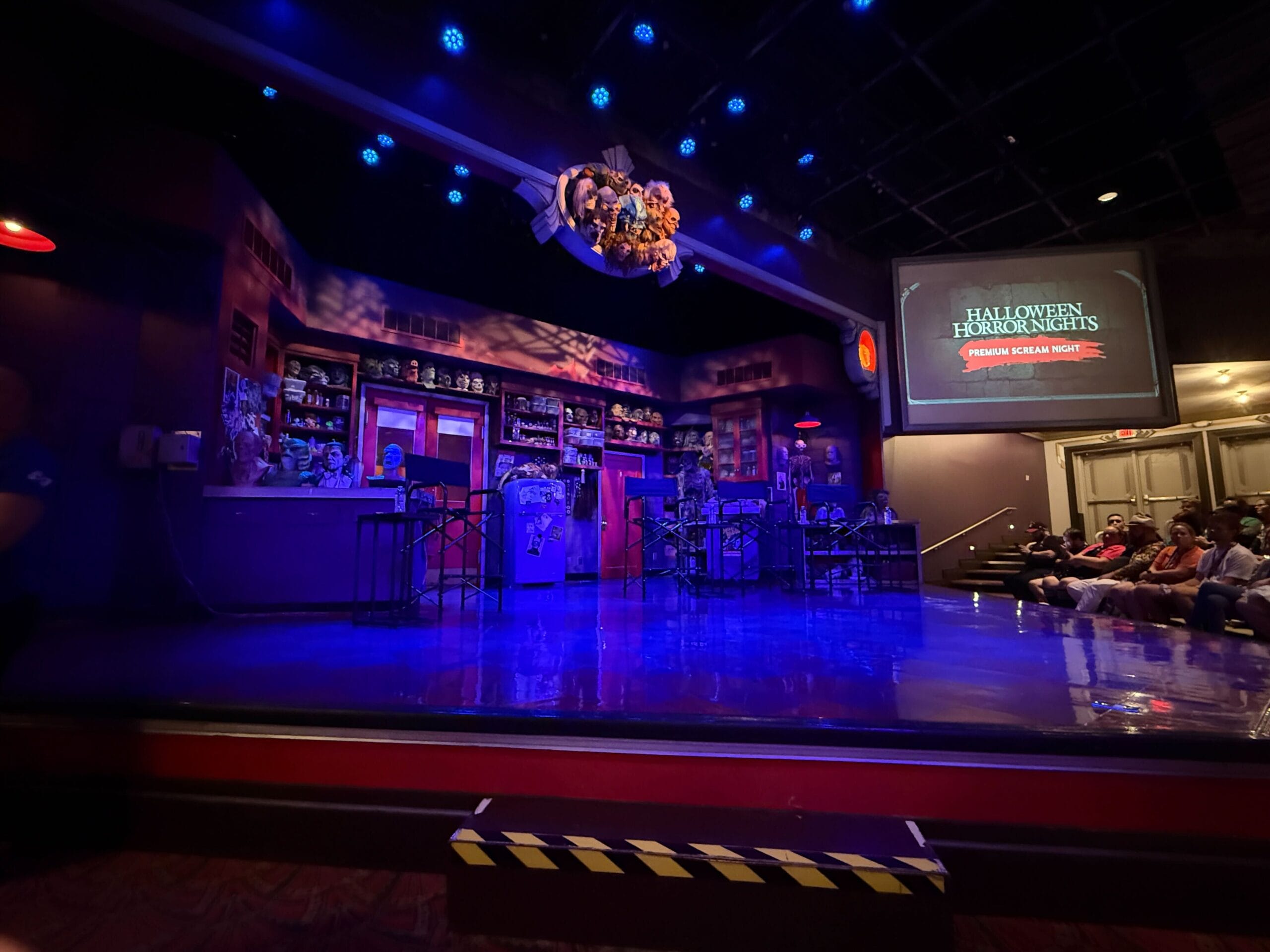A stage set for Halloween Horror Nights with blue lighting, props, and audience—perfect for a Premium Scream 2025 review.