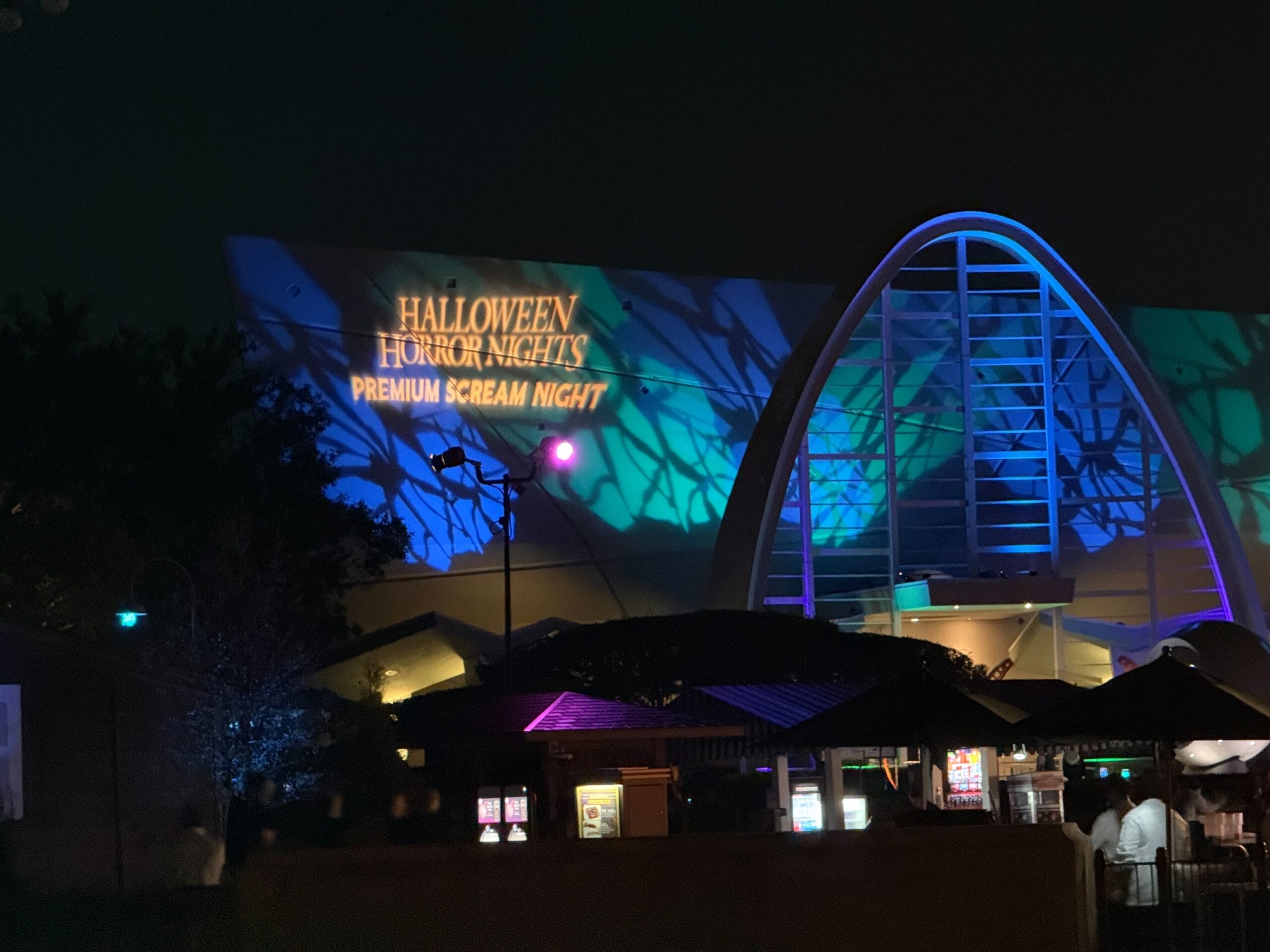 A building glows in blue and purple for Halloween Horror Nights Premium Scream 2025, dazzling all who review it.