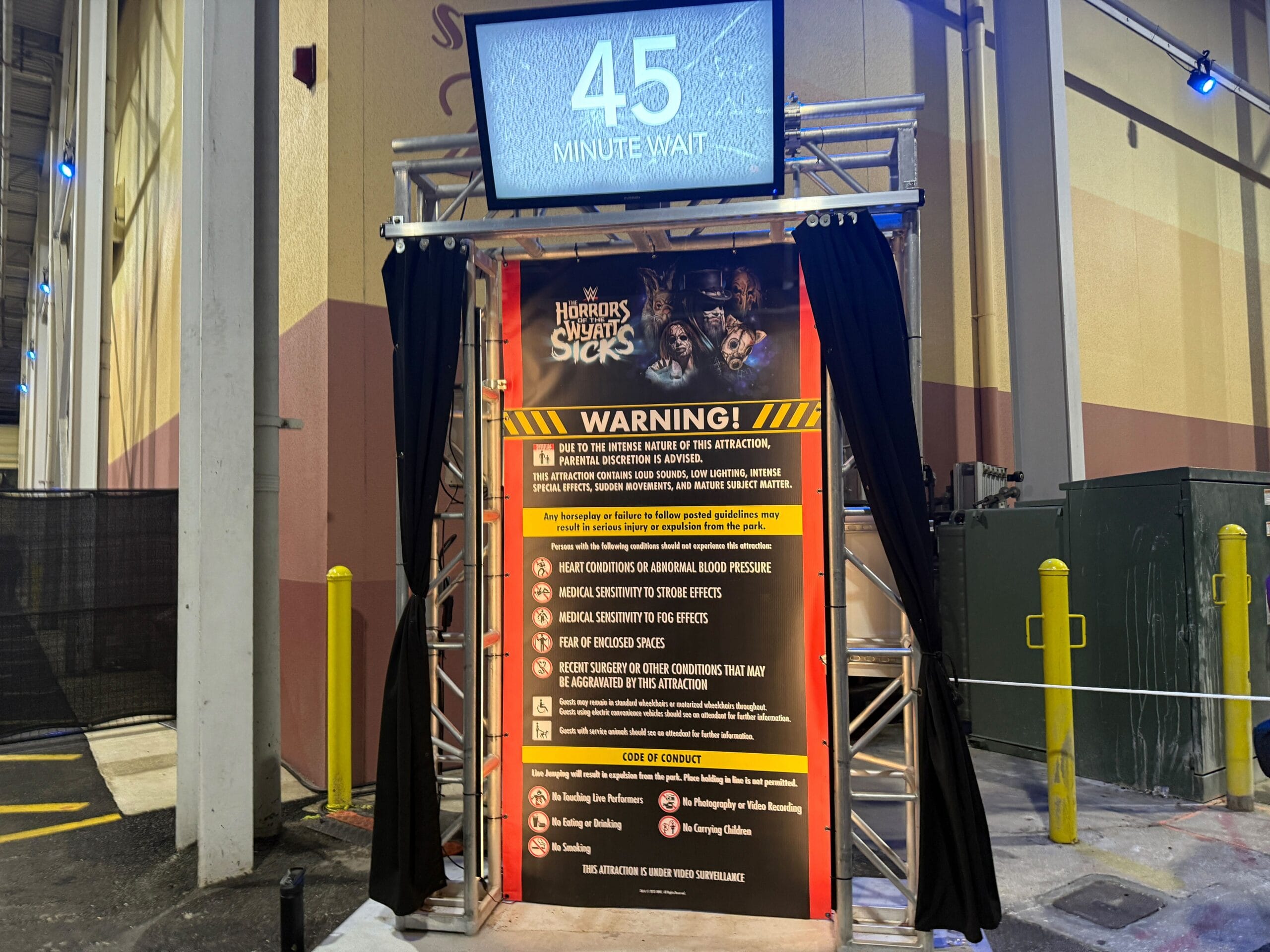 Entrance to a haunted house at Halloween Horror Nights with a 45-minute wait and large warning notice.