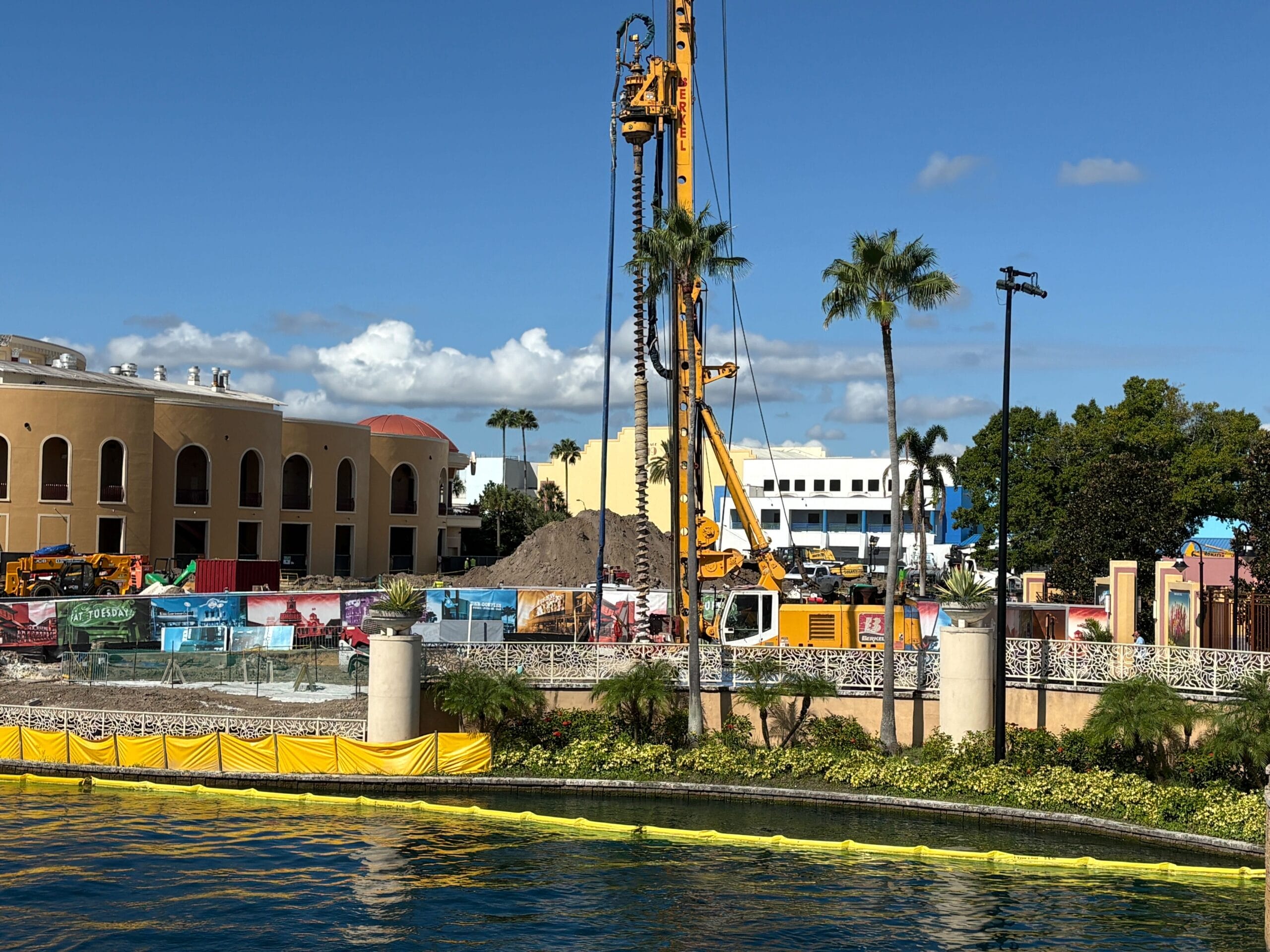 Construction site with large drilling equipment, dirt piles, and barriers near water hints at Rip Ride Rockit track removal.