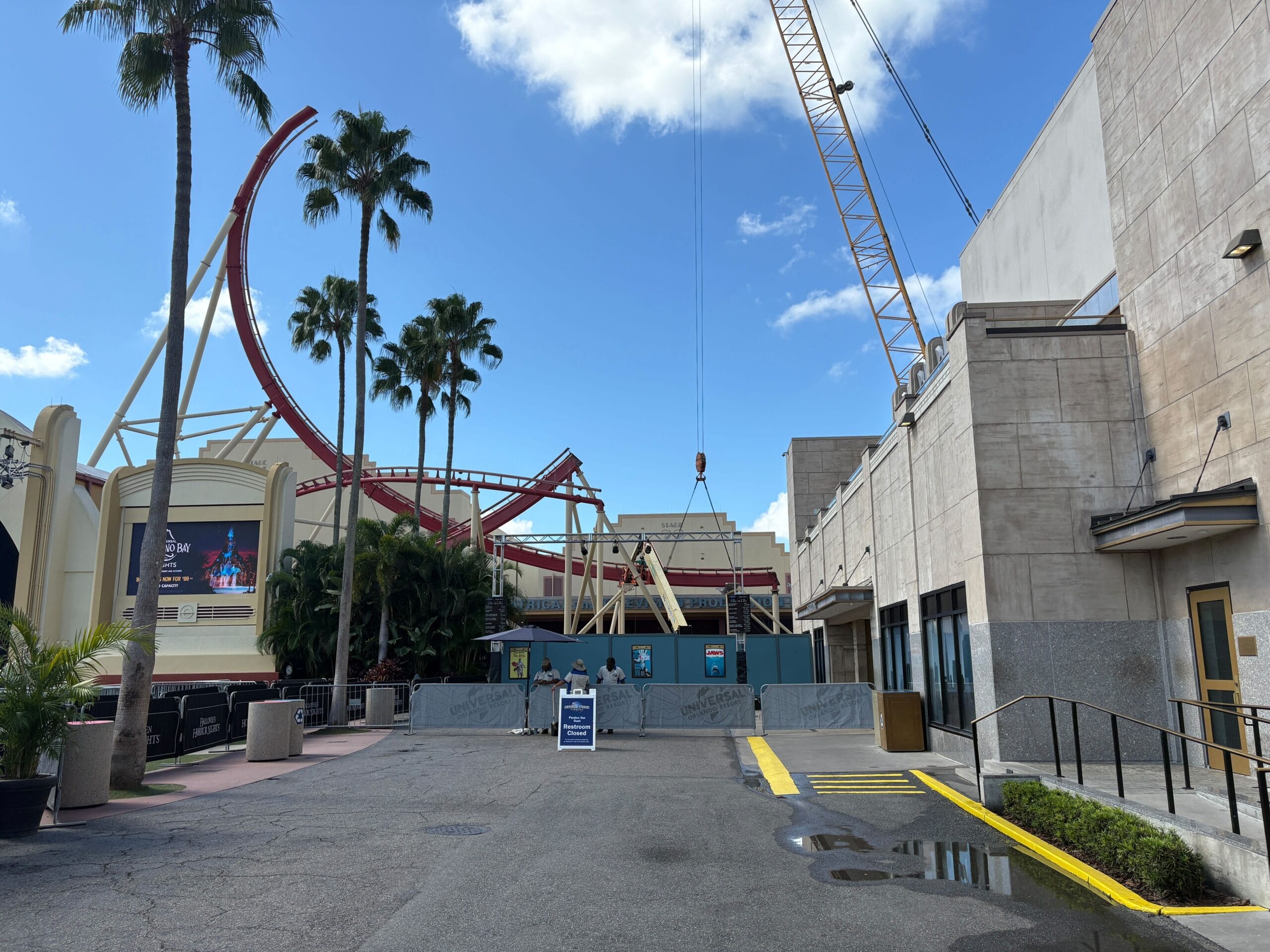 A construction area with signs and barricades near Rip Ride Rockit track removal at Universal Studios on a sunny day.