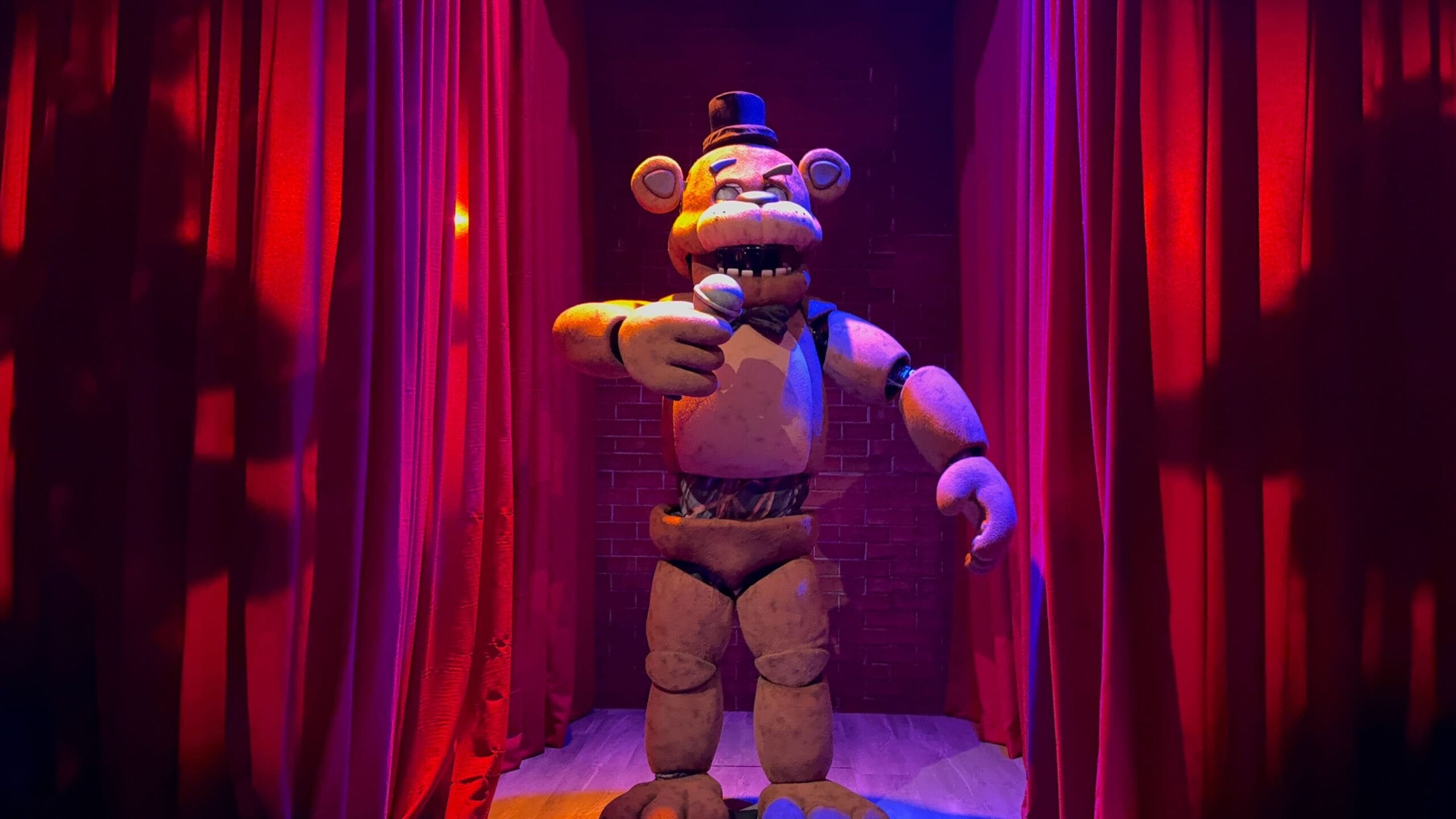 An animatronic bear wearing a top hat stands on stage, evoking Five Nights at Freddy’s at Universal Hollywood.