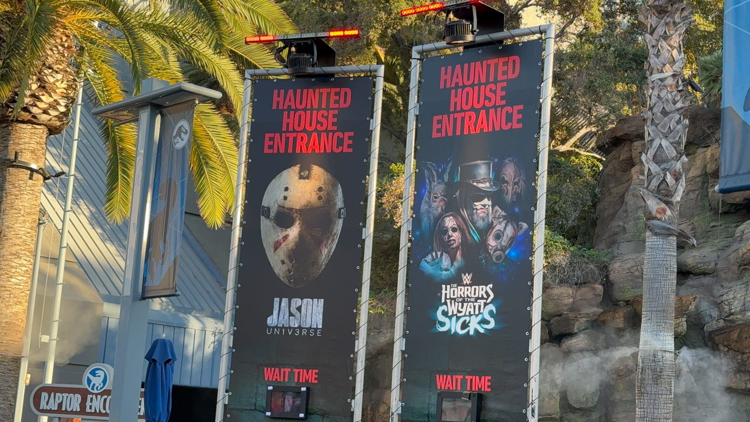 Two tall signs read "Haunted House Entrance," showing horror images for Jason Universe and The Horrors of WWY Sicks.