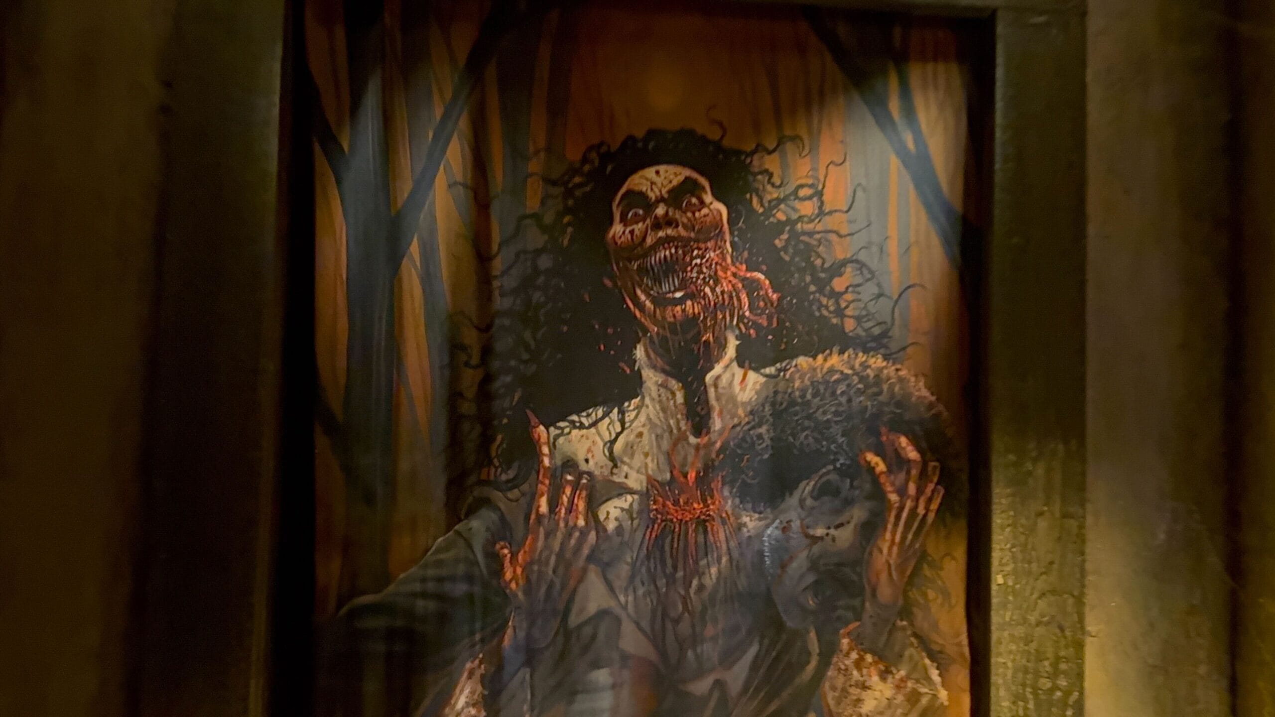 A creepy Monstros 3 painting shows a blood-soaked woman holding a severed head in an eerie, shadowy forest.