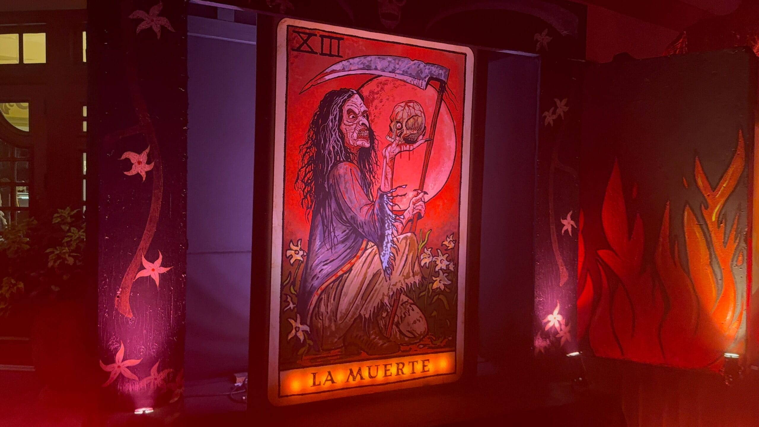 A tarot card labeled "La Muerte" shows a grim reaper with a scythe, evoking Latin American witches and red light.