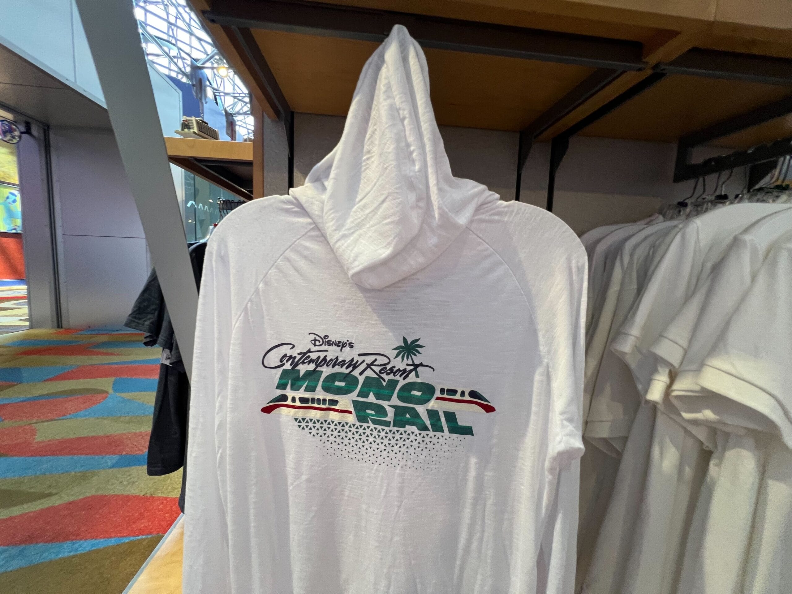 White hoodie from the Monorail Collection, featuring "Disney's Contemporary Resort MONORAIL" and a monorail graphic on the back.