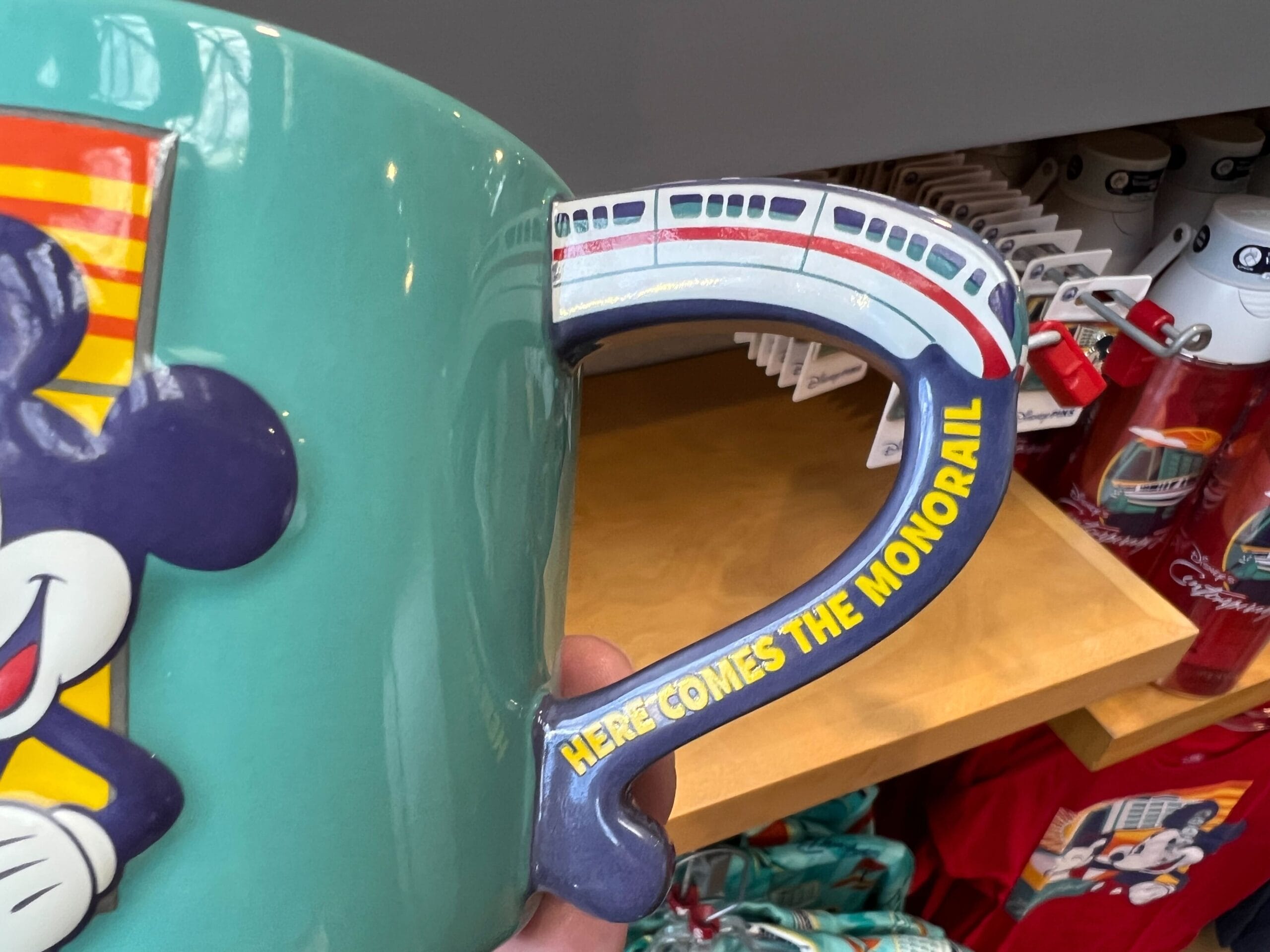 A mug from the Monorail Collection featuring Mickey Mouse and a monorail handle, inspired by Walt Disney World.