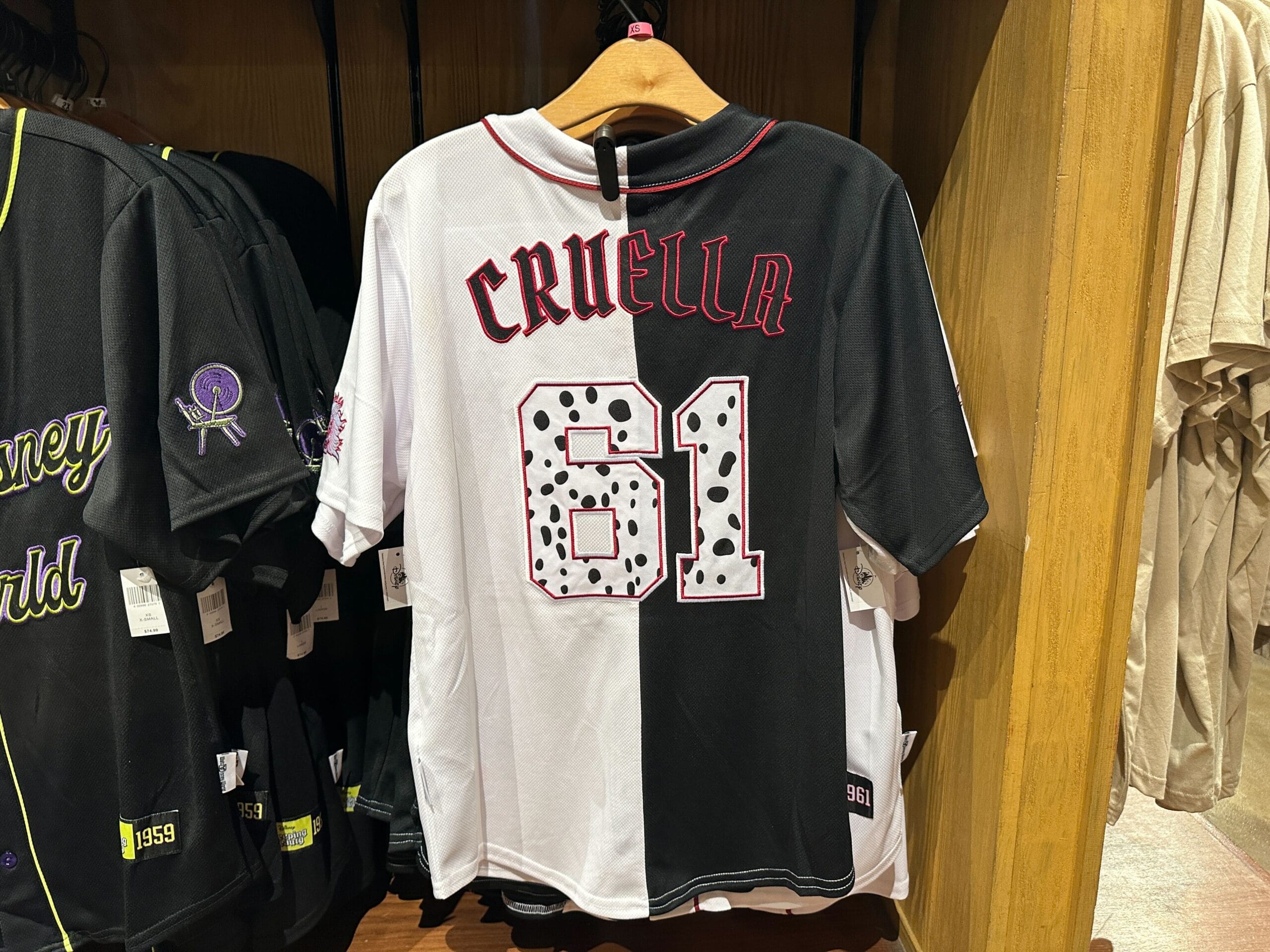 Cruella de Vil Baseball Jersey featuring "Cruella" and the number 61 in red with dalmatian print on the back.