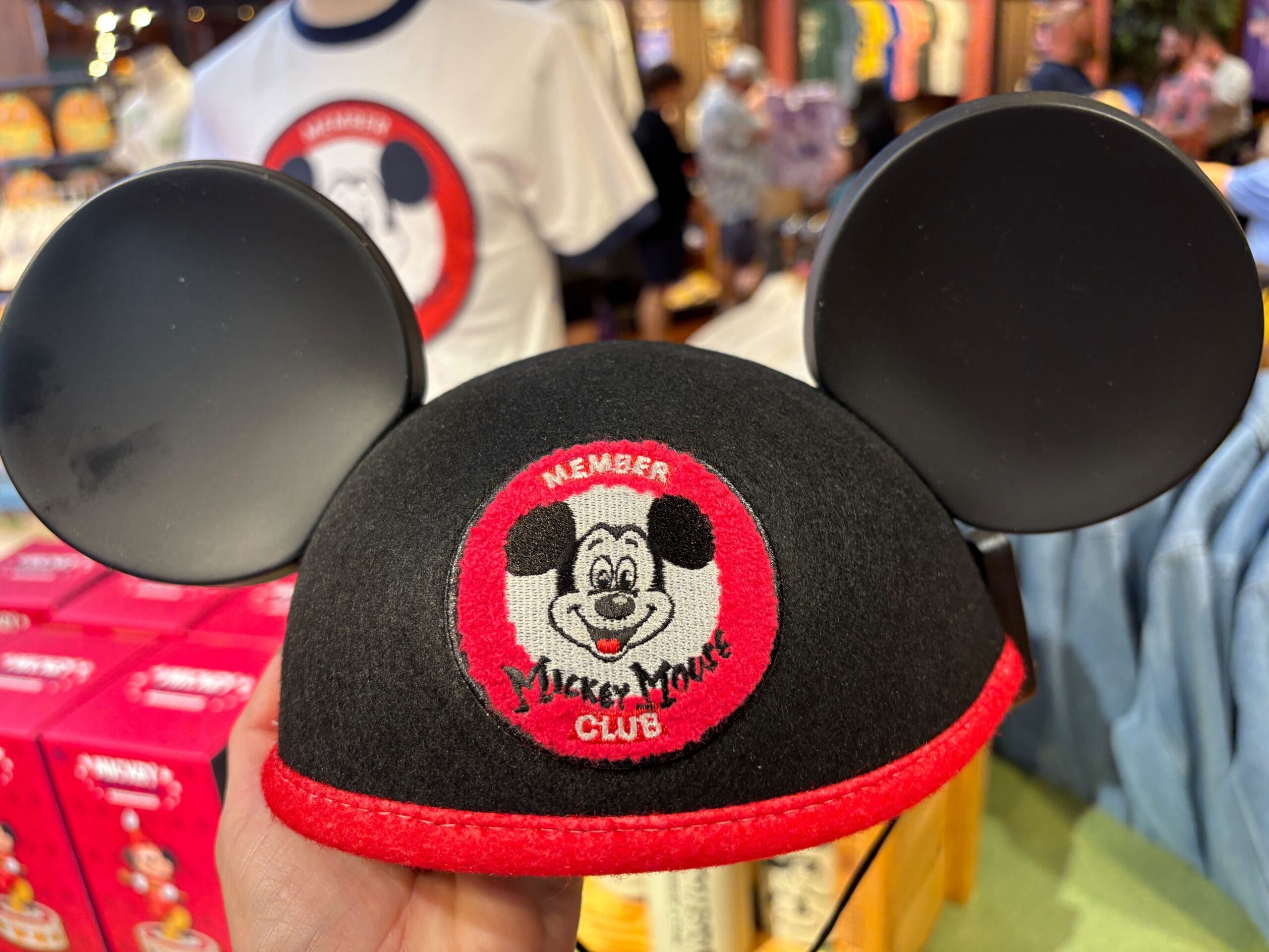 A hand holds classic Mickey Mouse Club ears hat from the exclusive 70th Collection.