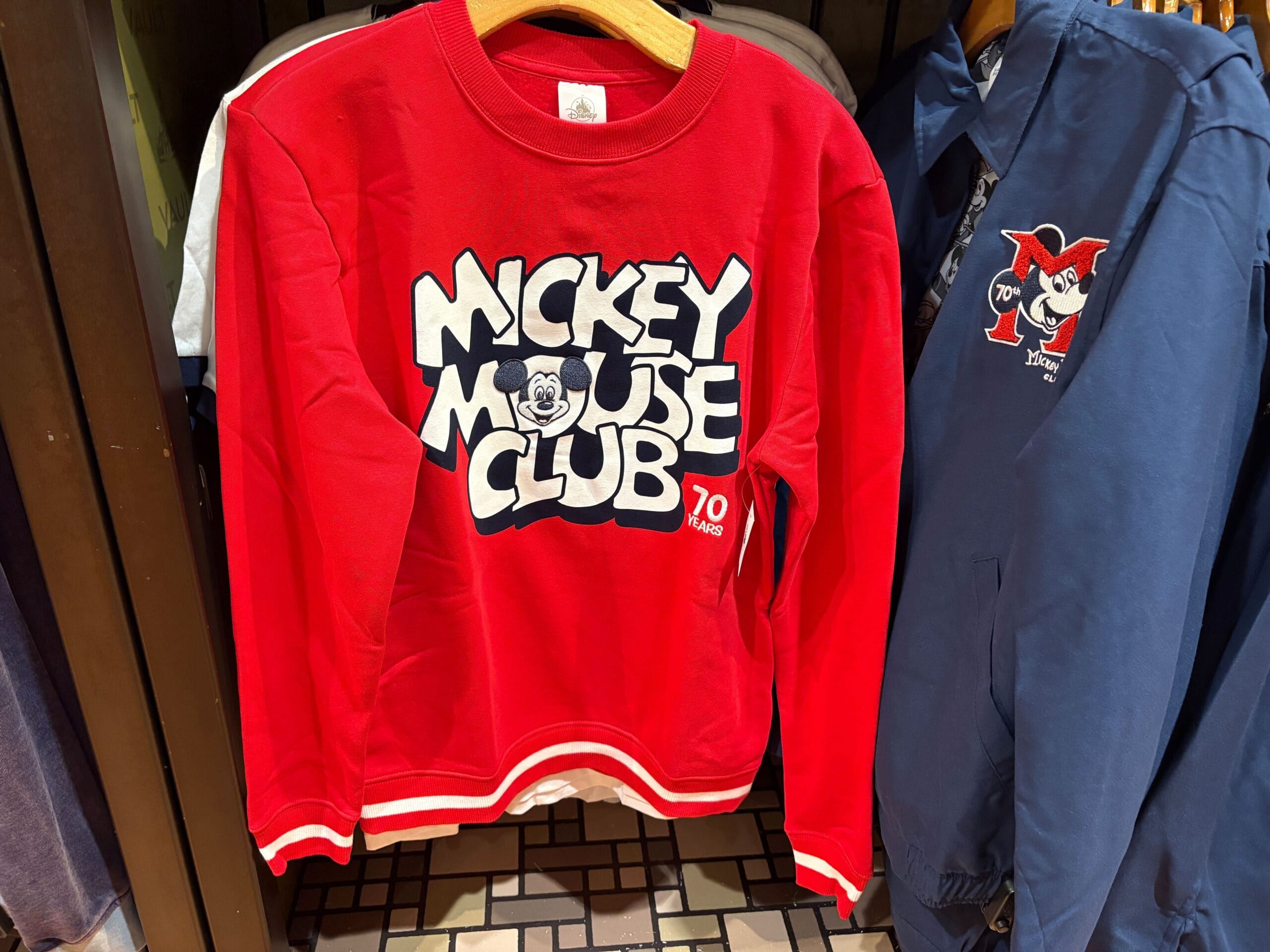 Red sweatshirt from the 70th Collection with "Mickey Mouse Club" and Mickey’s face; "70 years" printed in the corner.