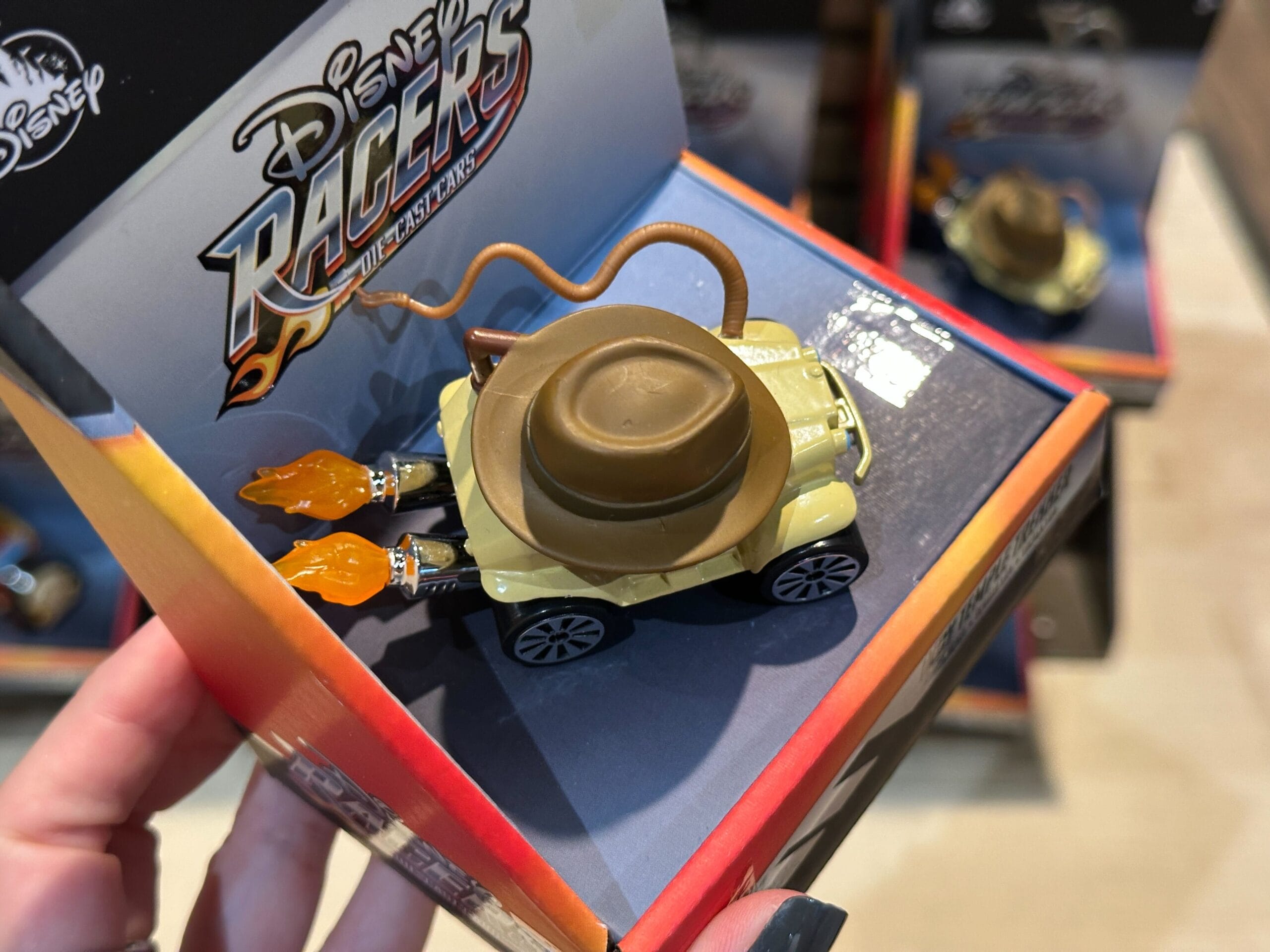 A Disney Racers Toy car with a hat and whip, inspired by Jungle Cruise, in themed Disney Racers packaging.