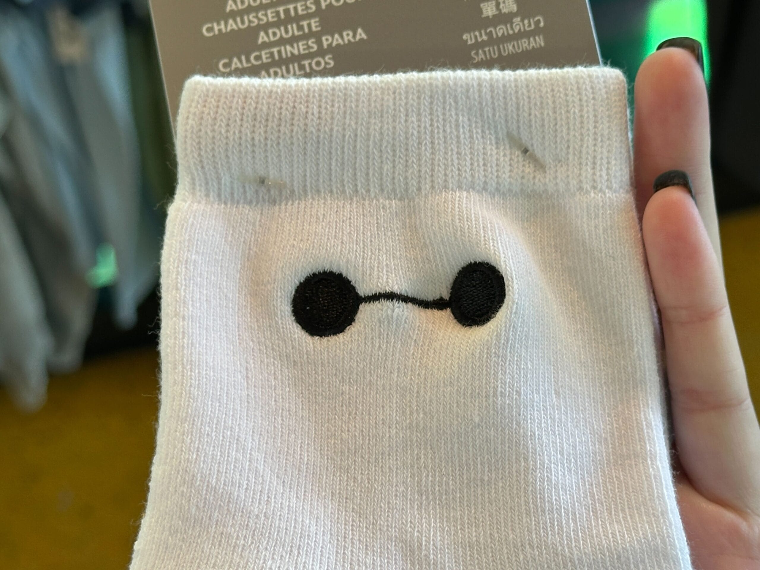 Novelty socks featuring a simple black line and two dots resembling Baymax's face from Big Hero 6.